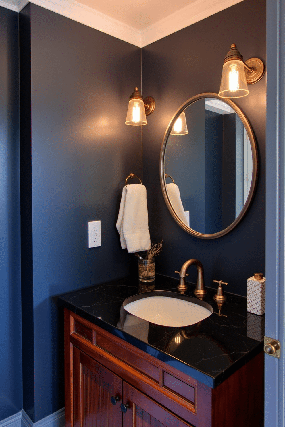 A moody powder room featuring vintage sconces with warm Edison bulbs illuminating the space. The walls are painted in a deep navy blue, complemented by a rich mahogany vanity with a polished black granite countertop.