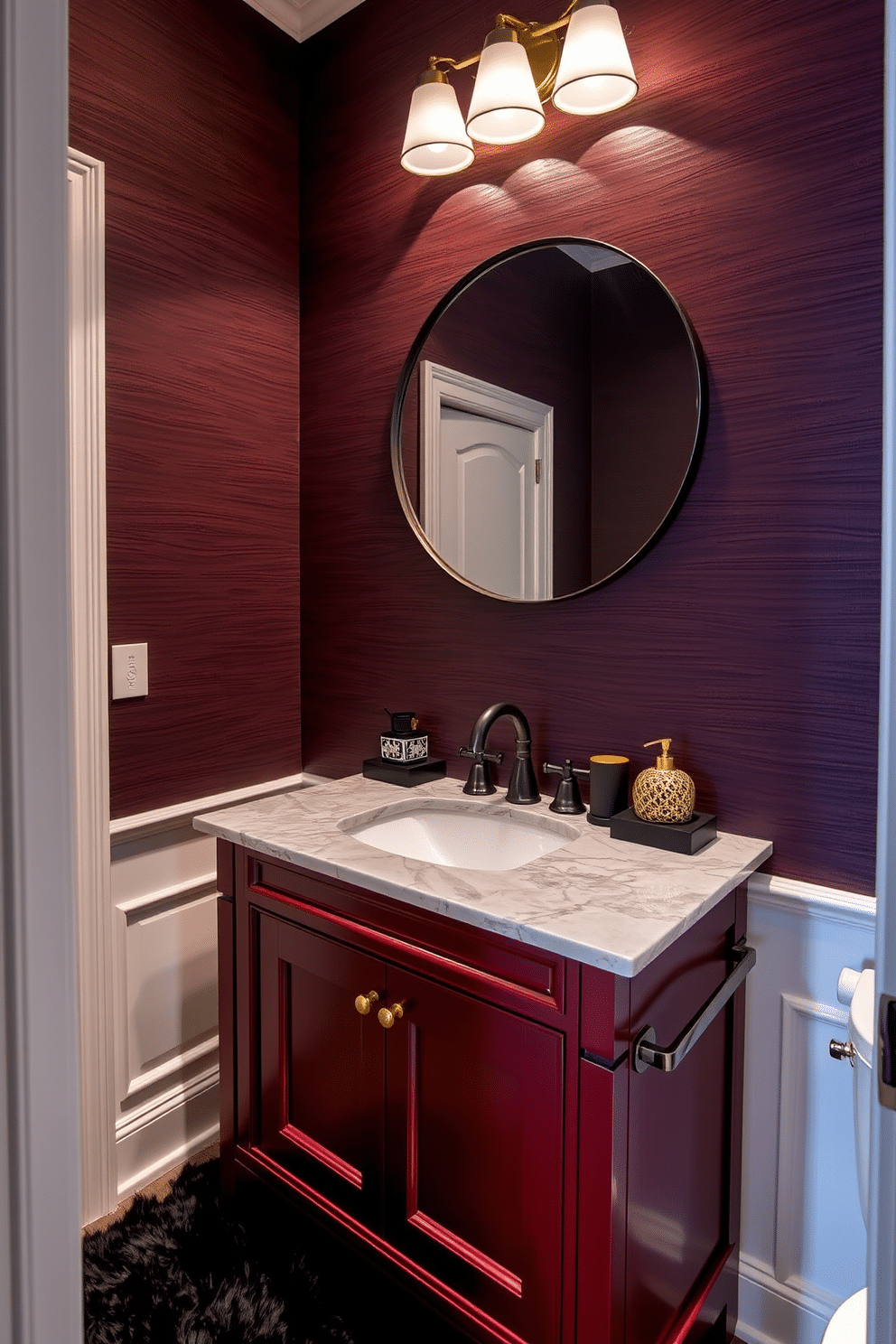 A rich burgundy vanity with a polished marble top serves as the centerpiece of this moody powder room. The walls are adorned with deep, textured wallpaper, creating an intimate atmosphere enhanced by soft, ambient lighting. A sleek, modern faucet complements the vanity, while a round mirror with a dark metal frame reflects the elegant design. Accessories in gold and black tones add a touch of luxury, and a plush, dark rug anchors the space beneath the vanity.