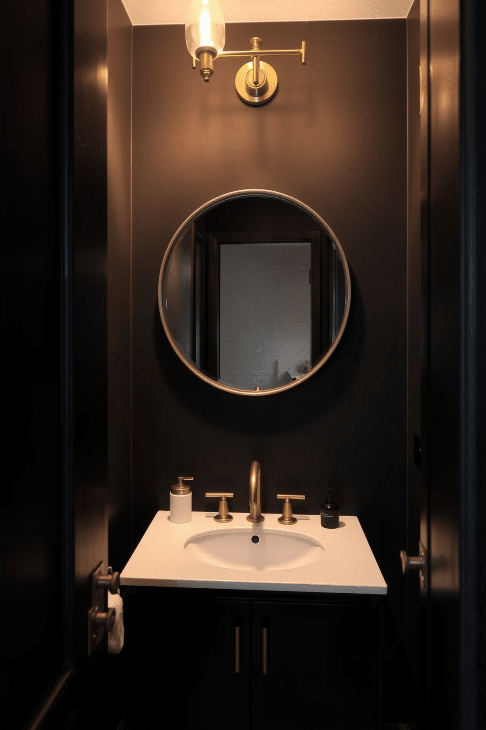 A moody powder room featuring soft black paint that envelops the space, creating an intimate atmosphere. Warm lighting fixtures cast a gentle glow, highlighting the elegant details of the design. The room includes a sleek, modern sink with a brushed gold faucet, complemented by a minimalist black vanity. A large round mirror with a gold frame reflects the ambient light, enhancing the sense of depth in the room.