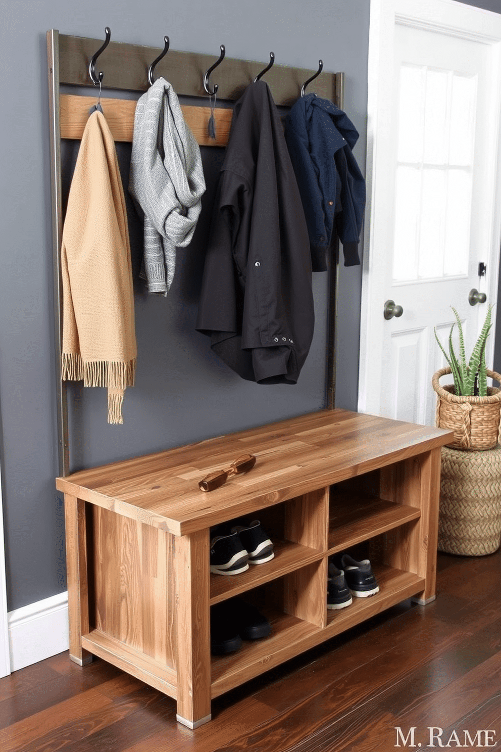 A stylish mudroom bench features an industrial metal frame supporting a rich, weathered wooden top. The bench is complemented by hooks above for hanging coats and a built-in storage compartment beneath for shoes and accessories.