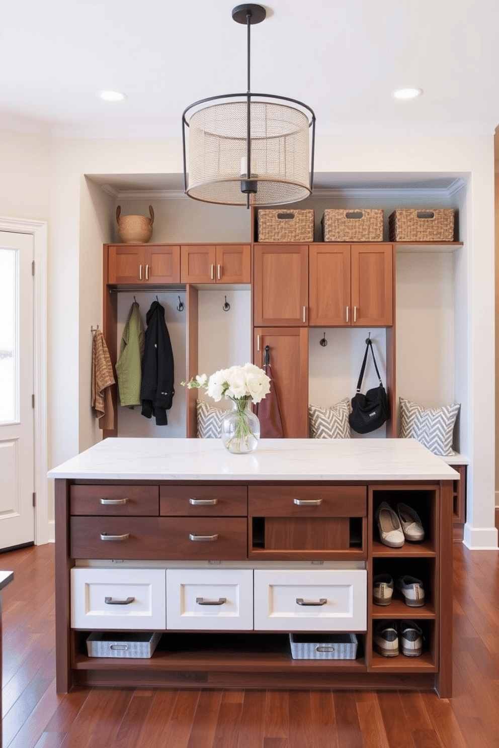 A multi-functional kitchen island features a sleek, modern design with a polished quartz countertop that extends into a breakfast bar, providing additional seating for four. Below the countertop, ample storage is available with deep drawers and open shelves for easy access to kitchen essentials. The mudroom closet design incorporates built-in benches with cushioned seating and hooks for hanging coats, creating an organized and welcoming entryway. Soft, neutral tones on the walls complement the rich wood cabinetry, while decorative baskets neatly store shoes and outdoor gear.