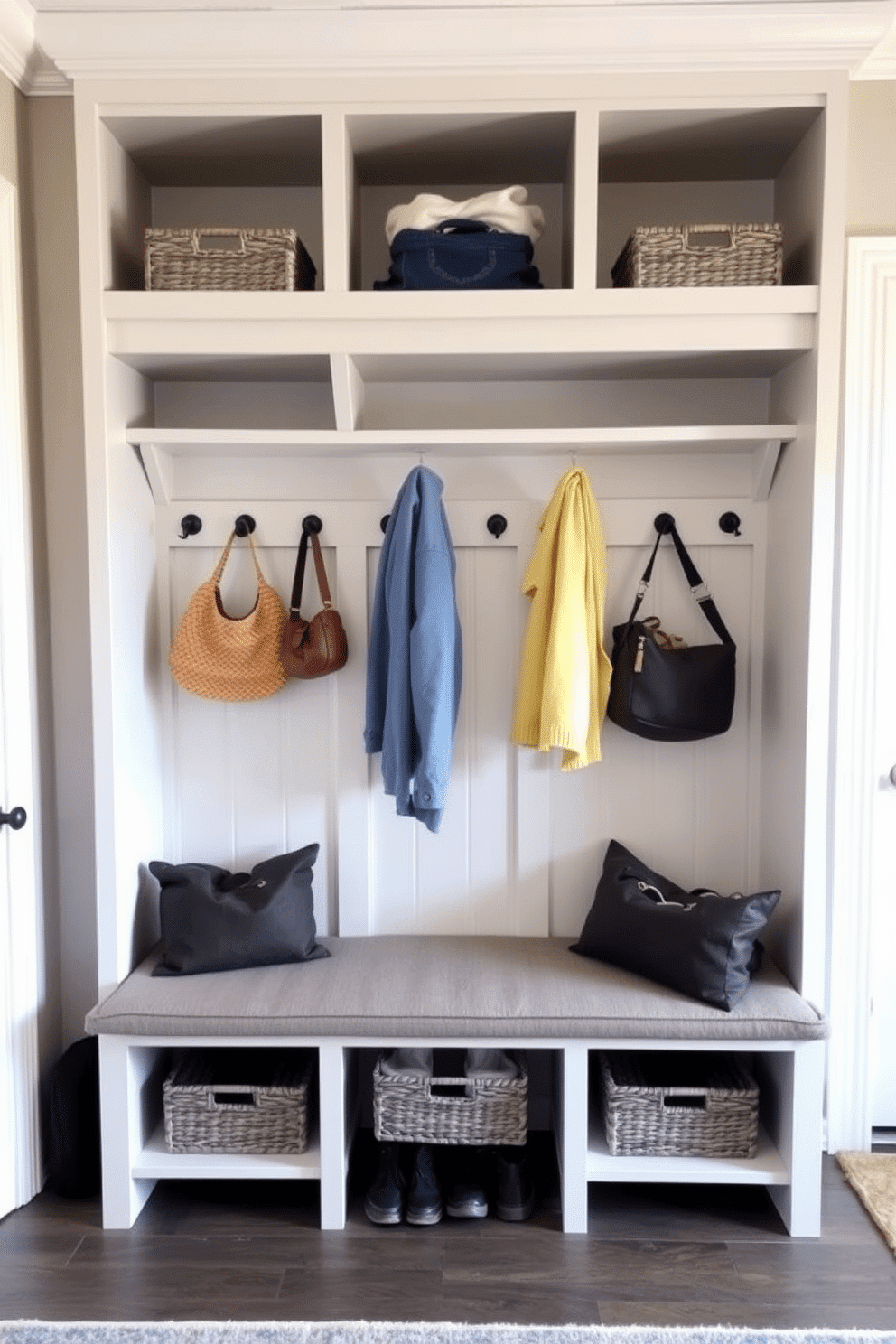 A stylish mudroom featuring a multi-functional bench with integrated shoe storage underneath. The bench is upholstered in a durable fabric, while the surrounding walls are adorned with hooks for coats and bags, creating an organized and inviting space. The cubby design incorporates open shelving above the bench for easy access to frequently used items. Each cubby is painted in a soft, neutral color, complemented by decorative baskets that provide additional storage and maintain a tidy appearance.