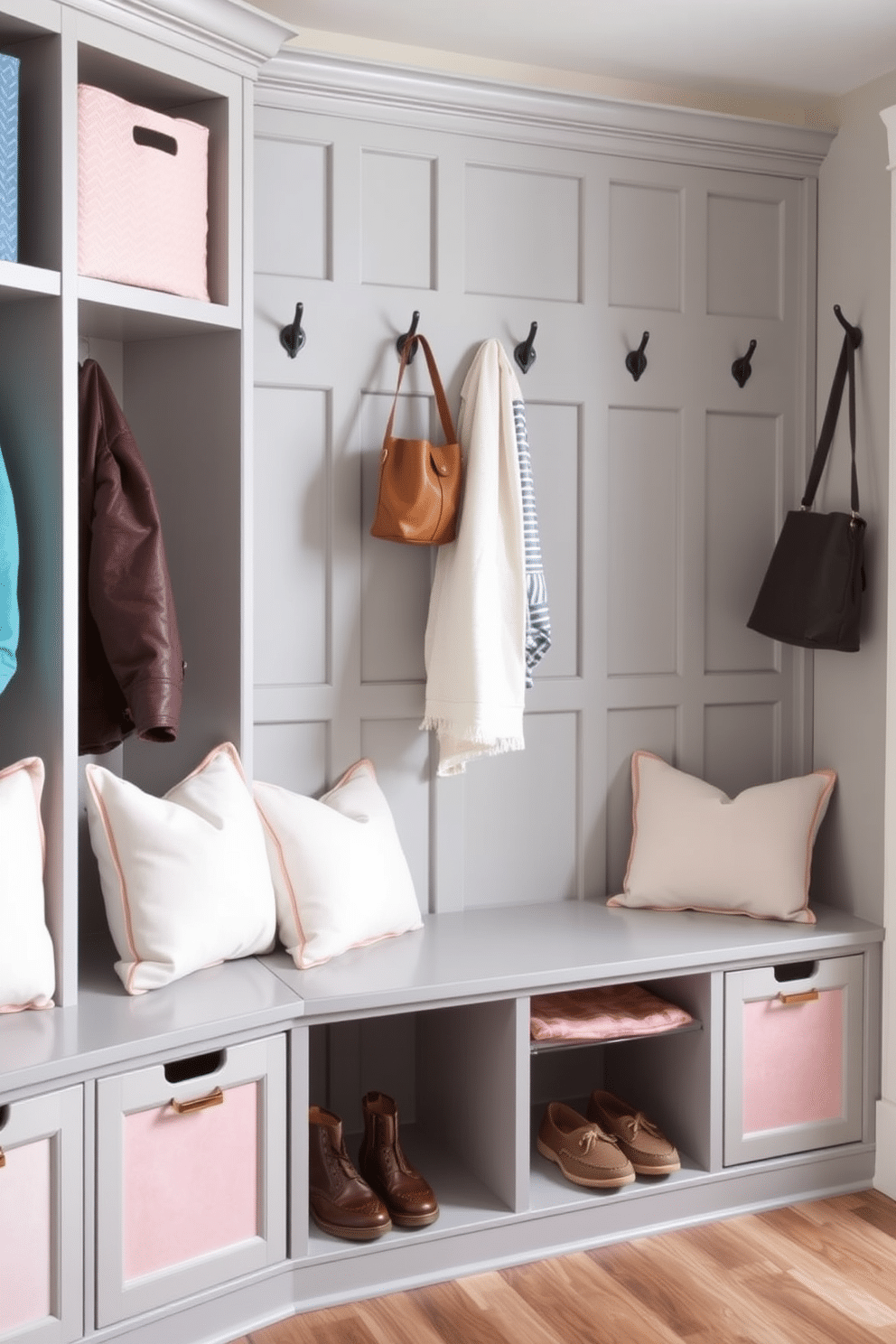 A functional mudroom featuring cubbies with removable fabric bins for easy organization. The cubbies are painted in a soft gray, complemented by stylish fabric bins in various pastel colors, creating a welcoming and cheerful atmosphere. The space includes a built-in bench with plush cushions, perfect for sitting while putting on or taking off shoes. Above the bench, hooks are arranged for hanging coats and bags, enhancing both practicality and aesthetic appeal.