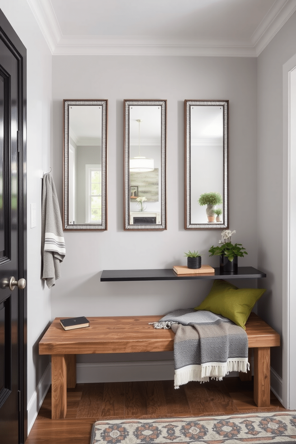 A stylish mudroom adjacent to the dining room features a row of decorative mirrors that reflect light and create an illusion of spaciousness. The walls are painted in a soft gray, complemented by a rustic wooden bench and hooks for coats, while a patterned rug adds warmth underfoot. Incorporating a sleek console table beneath the mirrors provides a functional space for keys and mail. Potted plants on the table and a cozy throw blanket on the bench enhance the inviting atmosphere of this transitional area.