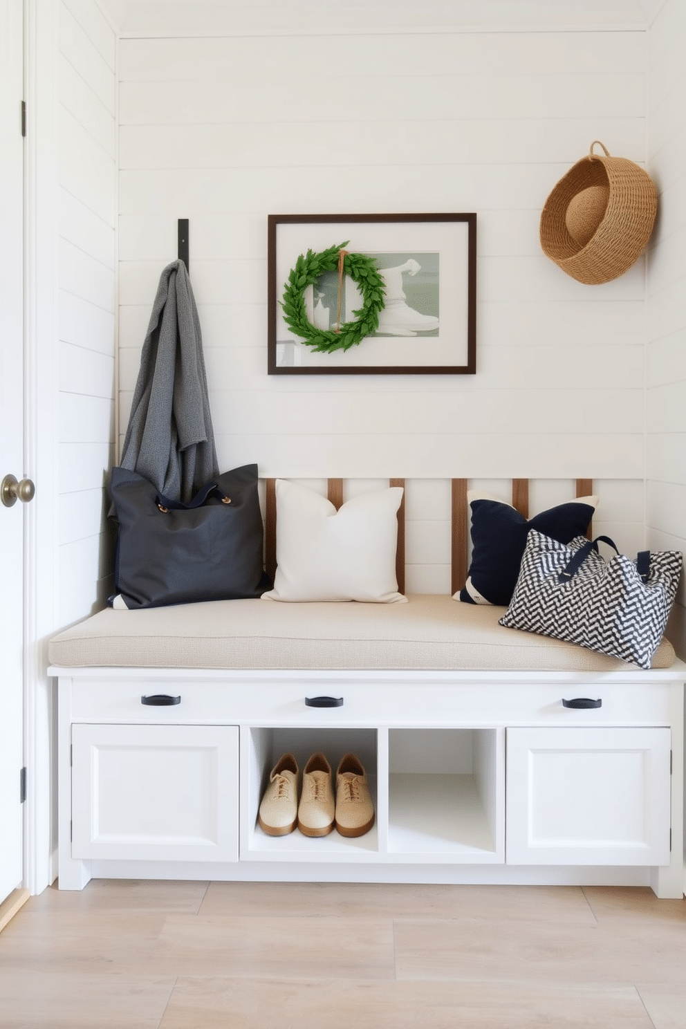 A stylish mudroom near the family room features a built-in bench with ample shoe storage underneath. The bench is upholstered in a soft, durable fabric, and the walls are adorned with shiplap in a light, airy color to create a welcoming atmosphere.