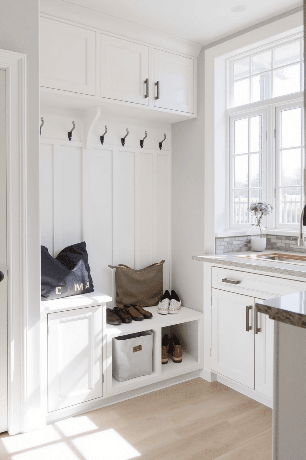 A functional mudroom design near the kitchen features a built-in bench with storage underneath, providing a convenient spot for shoes and bags. Above the bench, there are hooks for coats, and a large window allows natural light to brighten the space. Incorporated into the cabinetry, a hidden laundry hamper is discreetly located behind two matching doors, ensuring a tidy appearance. The color palette consists of soft whites and grays, creating a cohesive and inviting atmosphere.