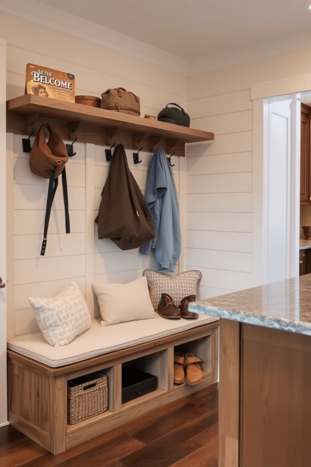 A cozy mudroom near the kitchen features built-in seating with plush cushions, providing a welcoming space for relaxation and storage. The walls are adorned with shiplap, and a rustic bench is complemented by a row of hooks for coats and bags, creating an organized yet inviting atmosphere.