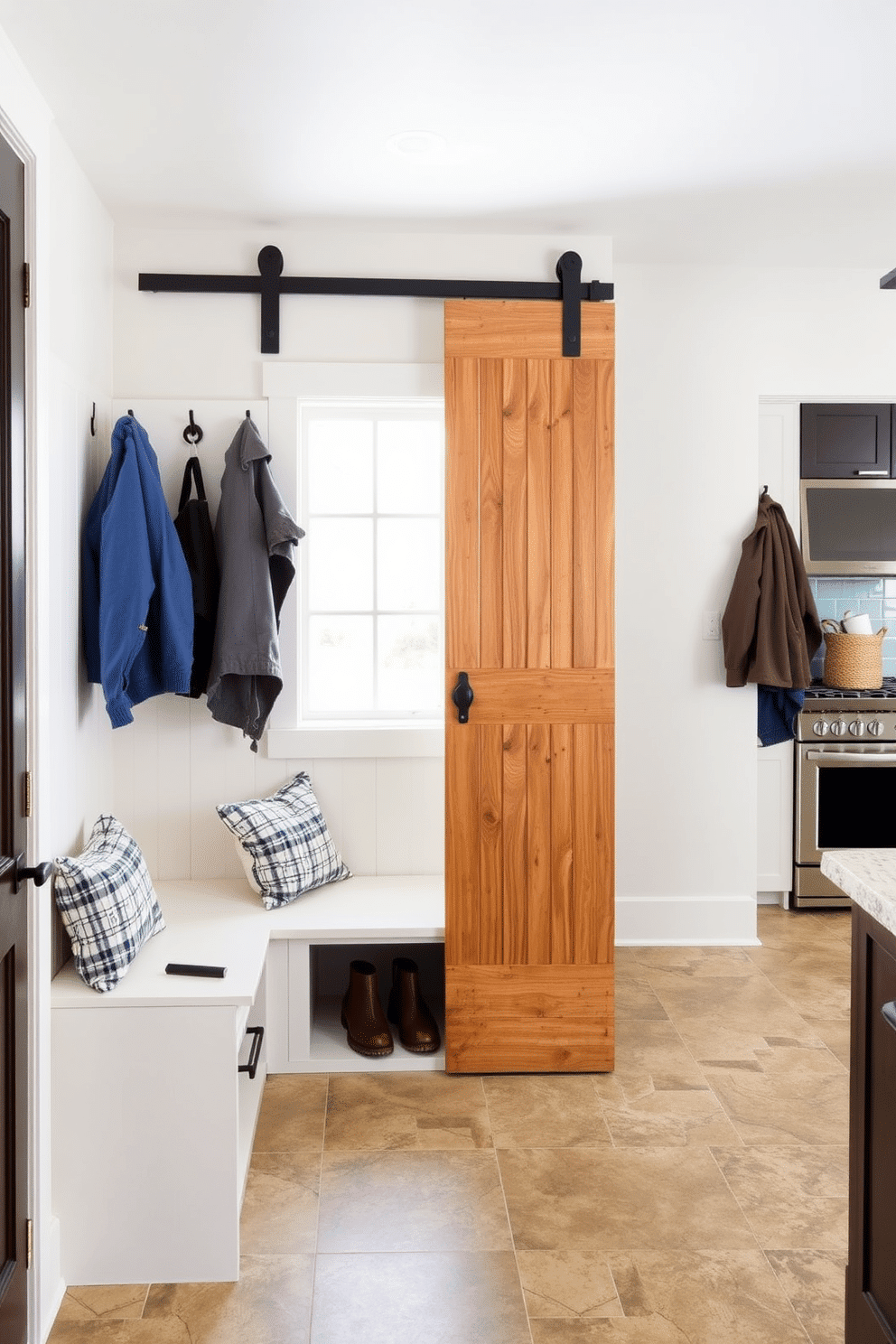 A spacious mudroom features a sliding barn door that seamlessly integrates with the overall design, providing space efficiency and a rustic charm. The room includes built-in storage benches and hooks for coats, with a stylish tile floor that complements the nearby kitchen's decor.