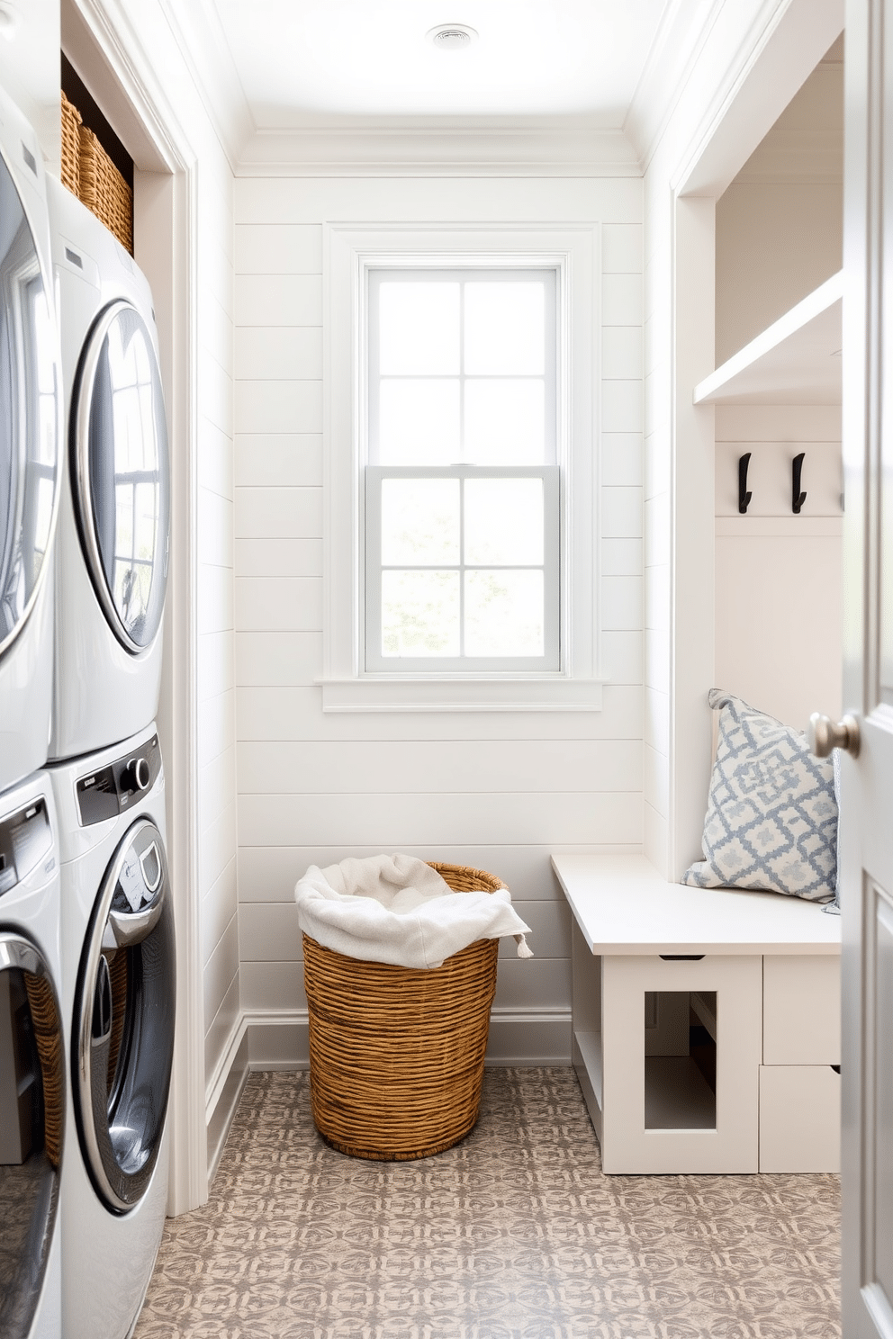 A stylish laundry basket for dirty clothes is placed in a chic corner of the laundry room, crafted from woven rattan with a soft linen liner. The room features a calming color palette of soft blues and whites, with a large window allowing natural light to illuminate the space. The mudroom near the living room is designed with functional elegance, showcasing built-in storage benches and hooks for easy organization. The walls are adorned with shiplap, and the flooring is a durable, patterned tile that complements the adjacent living area.