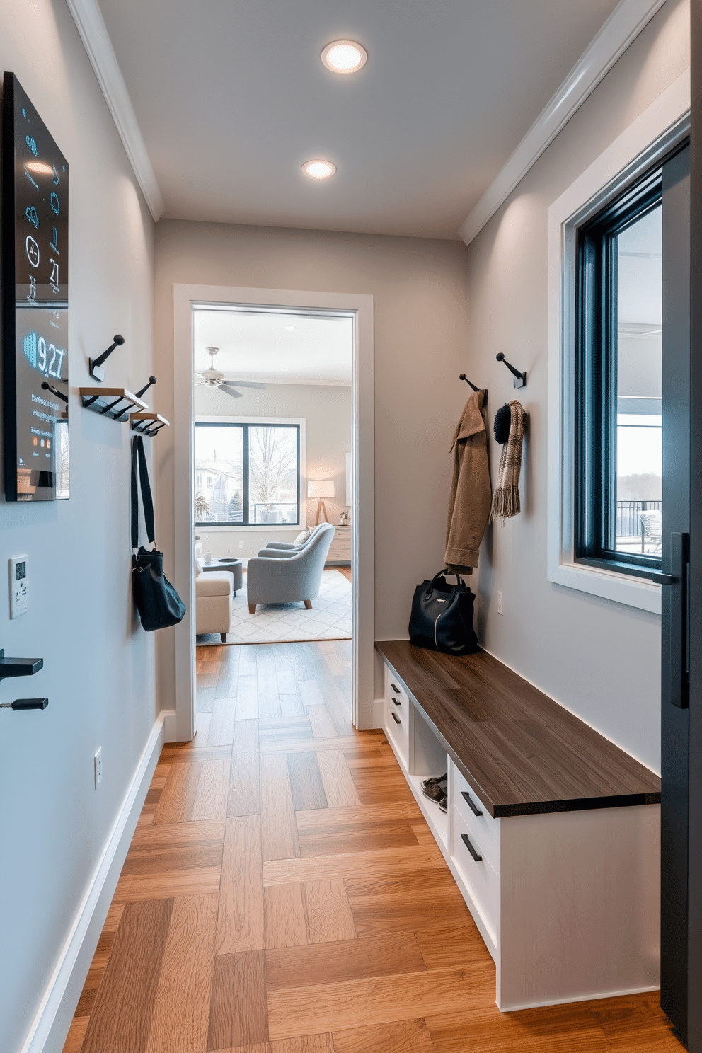 A modern mudroom adjacent to the living room features smart technology integrated into the design for enhanced convenience. The space includes a sleek built-in bench with storage compartments, equipped with charging ports and touch-screen controls for lighting and climate settings. The walls are adorned with stylish hooks for coats and bags, while a digital display panel shows weather updates and reminders. Durable flooring in a warm wood finish complements the contemporary aesthetic, and a large window allows natural light to flood the area, creating an inviting transition between the mudroom and living room.