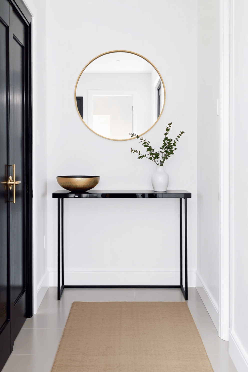 A sleek console table with a polished black finish sits against the wall, topped with a minimalist decorative bowl and a small potted plant. Above the table, a large round mirror with a thin gold frame reflects the light, enhancing the narrow entryway's sense of space. The walls are painted in a soft white hue, creating a bright and inviting atmosphere. A stylish runner rug in muted tones stretches along the floor, adding warmth and texture to the entryway.