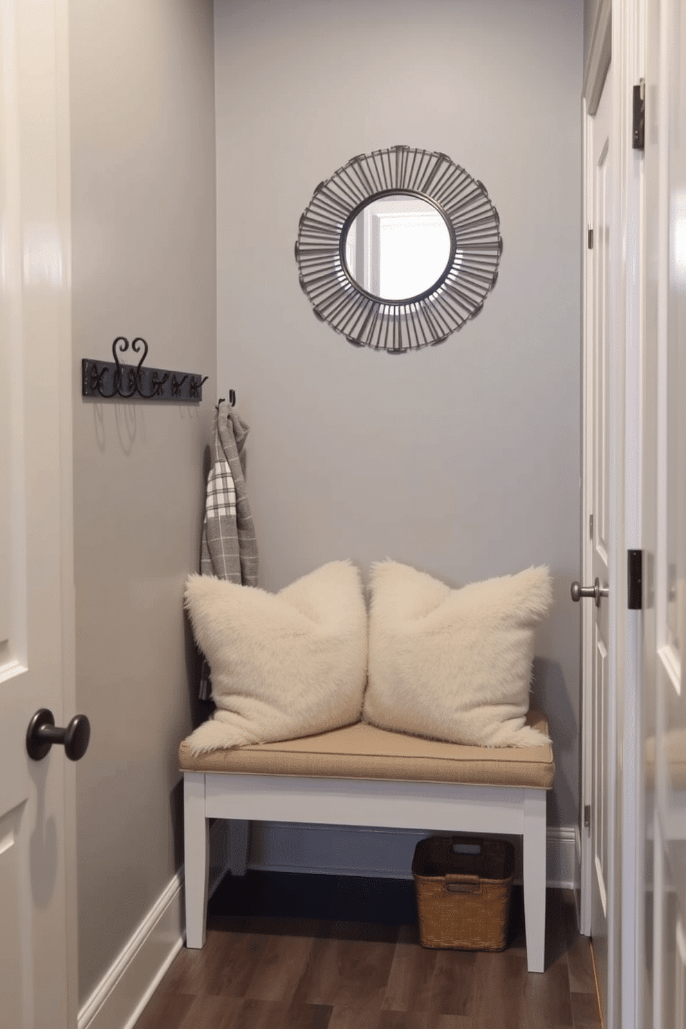 A narrow entryway featuring a small bench adorned with plush cushions for added comfort. The walls are painted in a soft gray, complemented by a stylish coat rack and a decorative mirror above the bench to enhance the space.