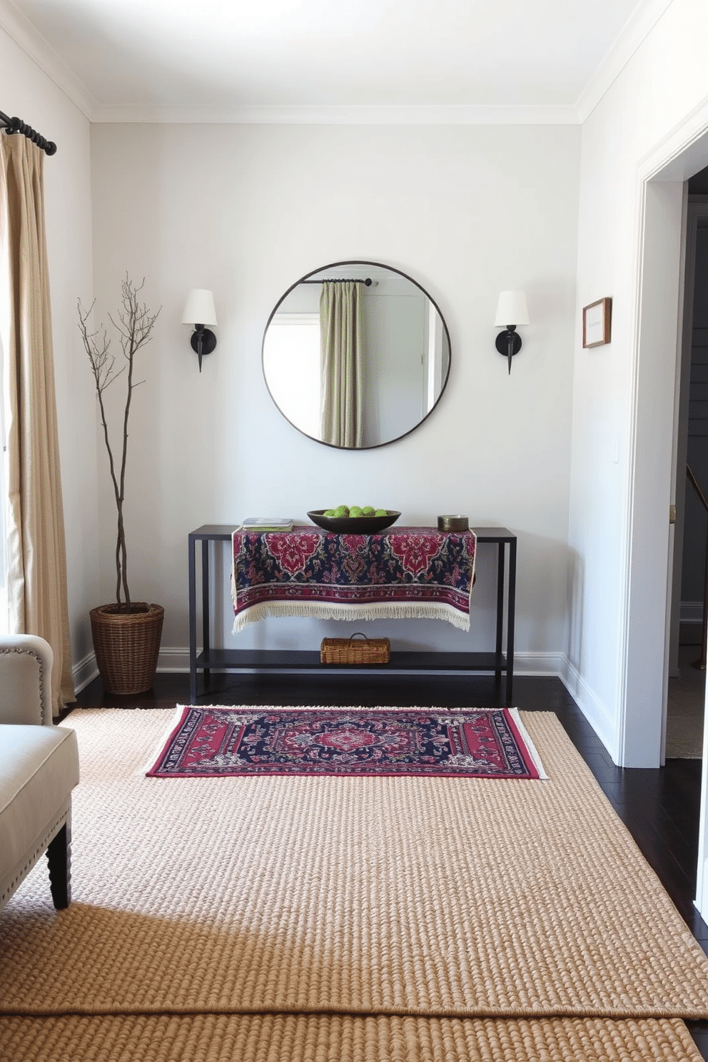 Layered rugs create a rich tapestry of texture and depth in a cozy living room. The bottom rug is a large, neutral jute design, while a smaller, colorful Persian rug sits atop, adding a vibrant focal point. In a narrow entryway, a sleek console table with a round mirror above creates an inviting space. Flanking the table, two stylish wall sconces provide warm lighting, enhancing the sense of depth and style.