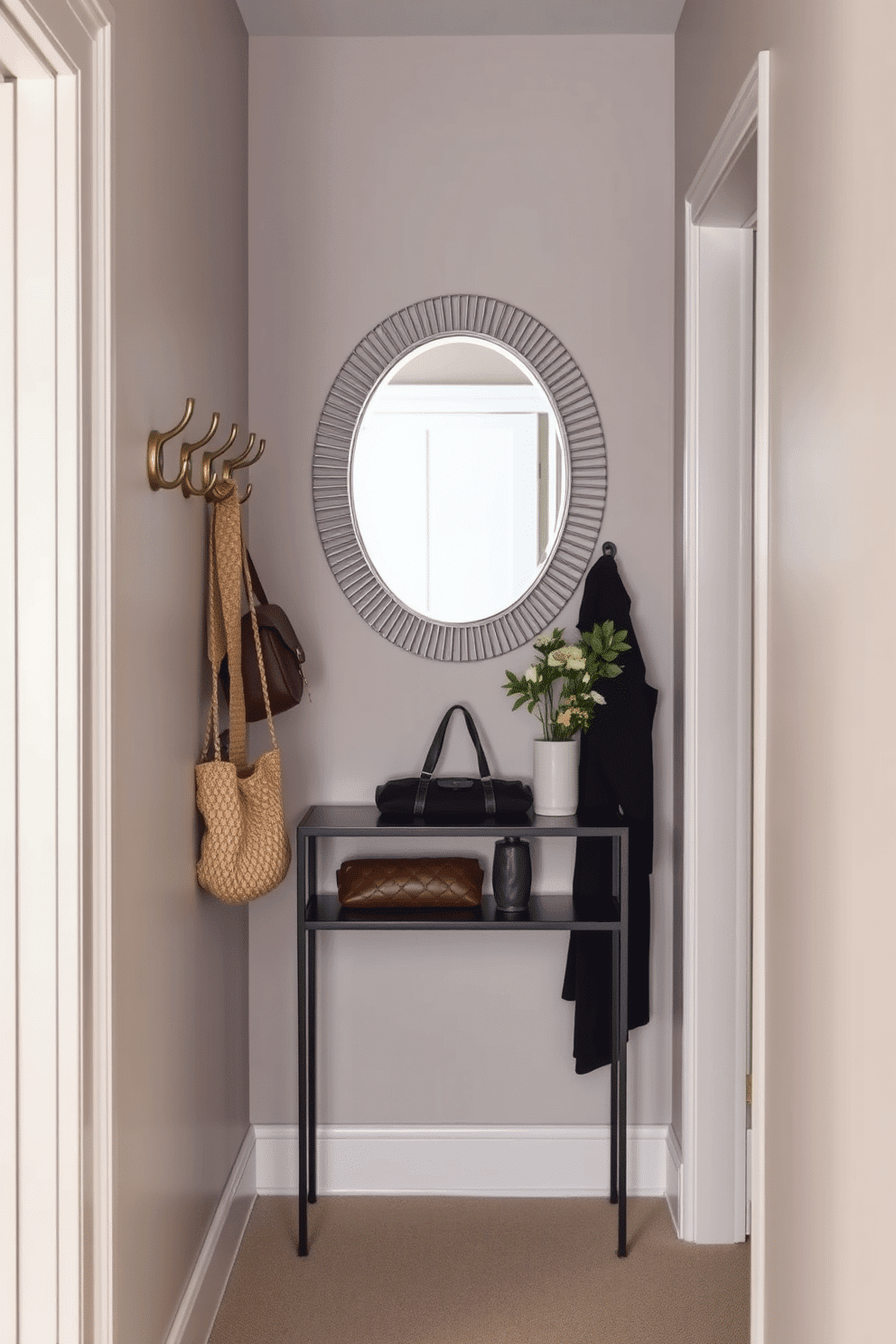 A narrow foyer designed for functionality and style features a set of sleek hooks mounted on the wall for coats and bags. The walls are painted in a soft, inviting color, while a narrow console table with a decorative mirror above it enhances the sense of space.