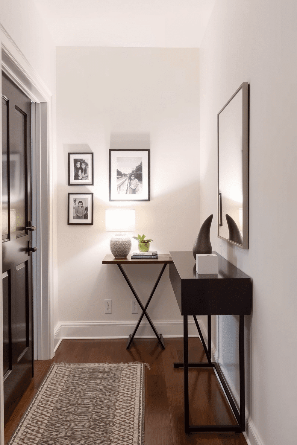 A narrow foyer features a sleek console table against the wall, adorned with a decorative lamp and a small potted plant. Framed photos of family and friends line the wall above the table, adding a personal touch and warmth to the entryway. The walls are painted in a soft, inviting color, enhancing the sense of space in the narrow area. A stylish runner rug in a geometric pattern adds texture and guides guests into the home, while a mirror opposite the entry creates an illusion of depth.