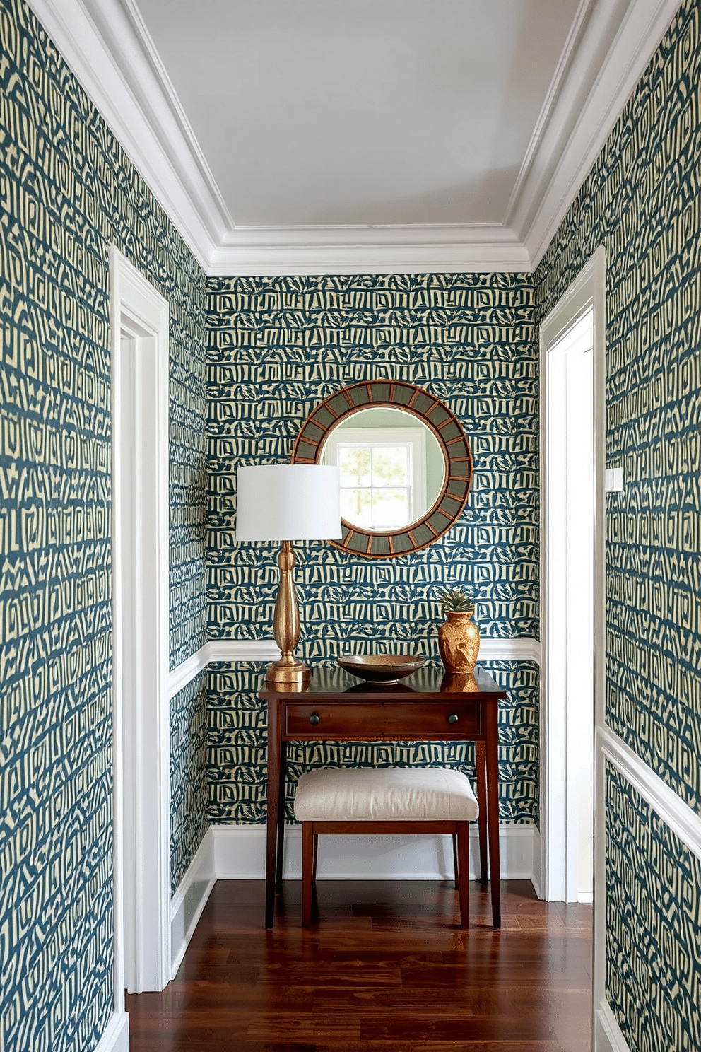 A narrow foyer features bold wallpaper with a striking geometric pattern that creates a captivating first impression. A sleek console table in a rich wood finish stands against the wall, adorned with a stylish lamp and a decorative bowl for added functionality. The ceiling is accentuated with elegant crown molding, enhancing the sense of height in the space. A round mirror with a decorative frame reflects light and adds depth, while a small bench provides a cozy spot for putting on shoes.