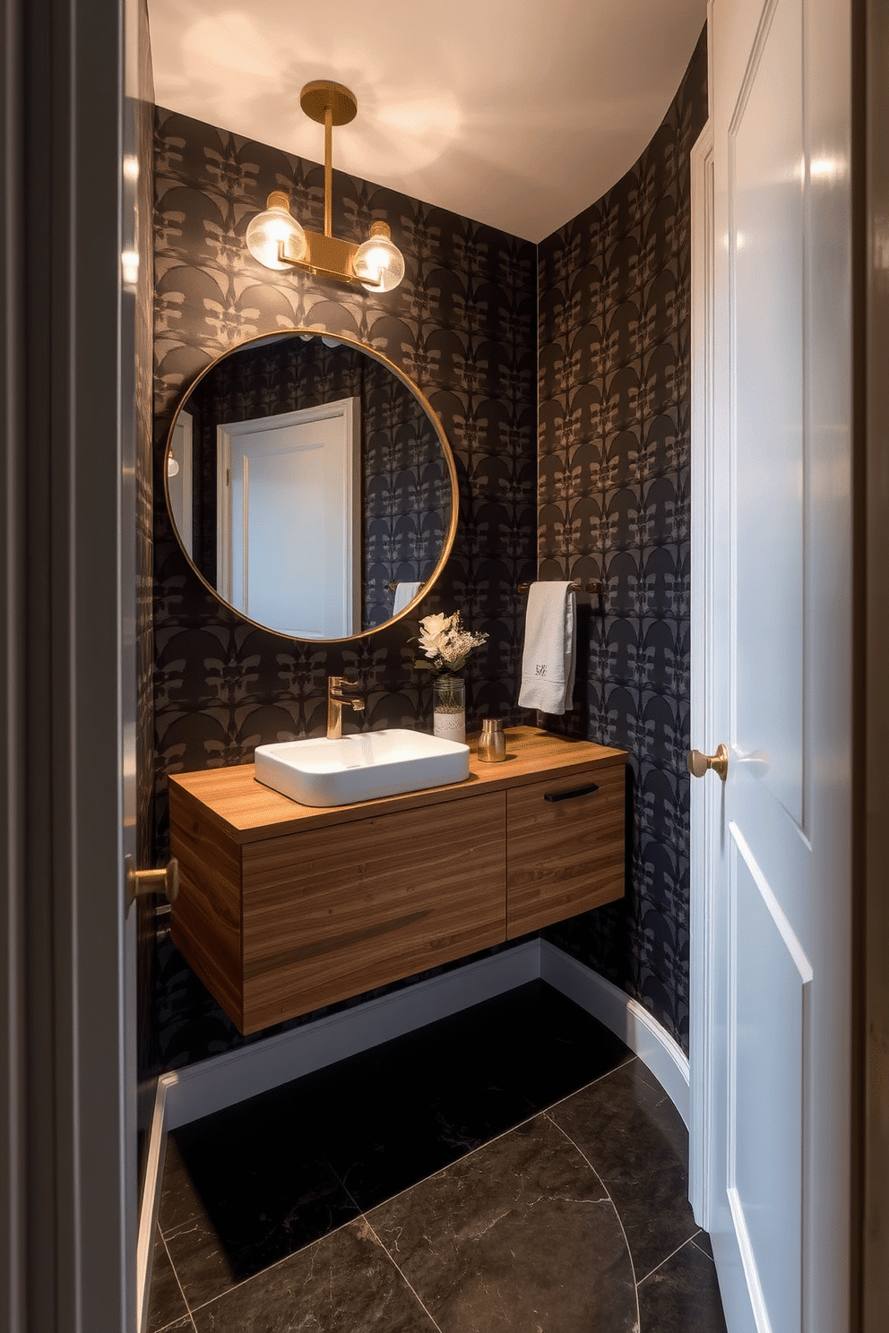 A narrow powder room features a stunning floating vanity adorned with a sleek, modern sink and stylish brass fixtures. The walls are covered in bold, graphic wallpaper that creates a striking contrast, while a large round mirror enhances the sense of space. The floor is laid with elegant, dark tiles that complement the vanity's wood finish. Soft lighting fixtures above the mirror provide a warm glow, making the room feel inviting and chic.