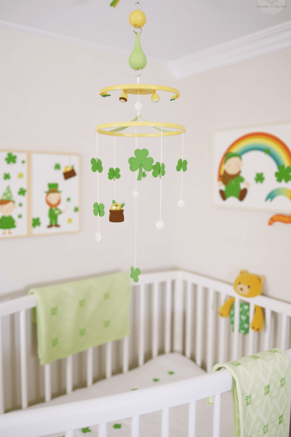 A charming St. Patrick's Day themed baby mobile hangs gracefully from the ceiling, adorned with soft felt shamrocks, tiny leprechauns, and miniature pots of gold. The mobile sways gently, creating a whimsical atmosphere in the nursery, with a soothing color palette of greens and golds. The nursery is decorated with St. Patrick's Day accents, featuring a cozy crib draped in a light green blanket adorned with playful clovers. Wall art showcases cheerful leprechauns and rainbows, while plush toys in festive colors add a touch of fun and comfort to the space.