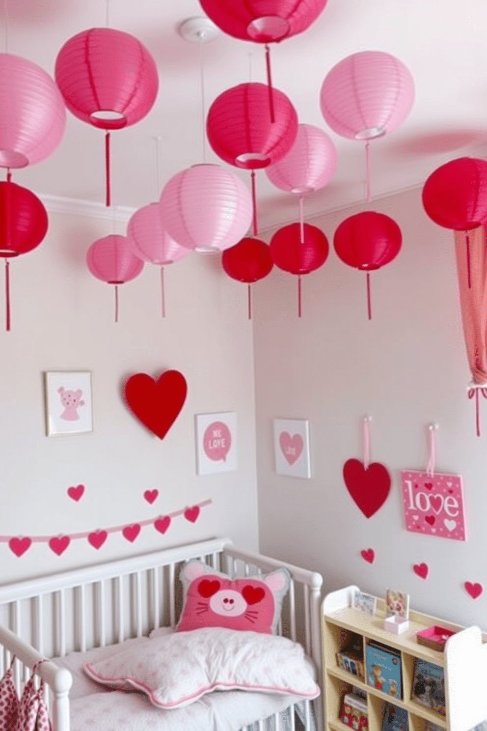 A whimsical nursery decorated for Valentine's Day features an array of pink and red paper lanterns hanging from the ceiling, casting a soft glow throughout the room. The walls are adorned with heart-themed artwork, and a cozy reading nook is set up with plush cushions and a small bookshelf filled with love-themed children's stories.