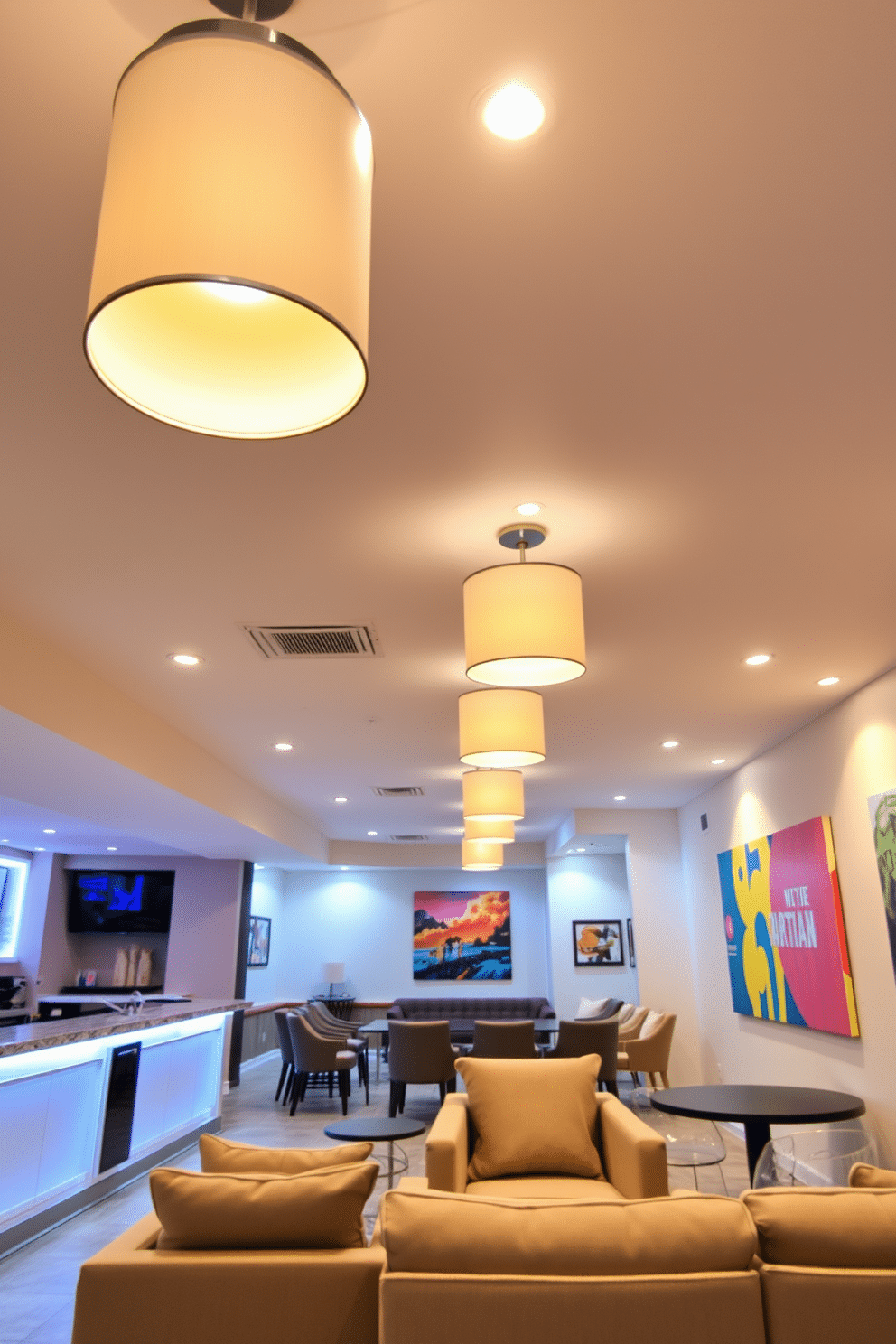 A bright and airy basement space features modern lighting fixtures that illuminate the area with warm, inviting light. The ceiling is adorned with sleek pendant lights, while recessed lighting highlights key areas, creating a cozy atmosphere. The design includes an open layout with a seamless flow between the entertainment area and a stylish bar. Plush seating arrangements and vibrant artwork enhance the inviting ambiance, making it a perfect space for gatherings.