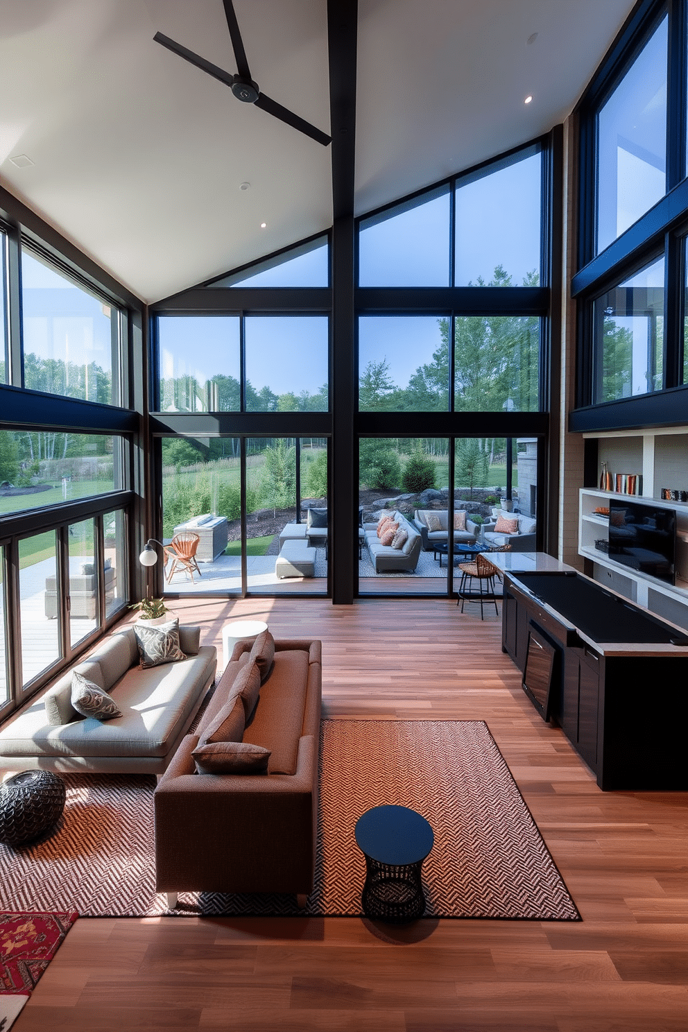 Outdoor-inspired space with large windows. The room features expansive floor-to-ceiling windows that invite natural light and provide a seamless connection to the surrounding landscape. Open basement design ideas. The layout emphasizes an airy feel with minimal partitions, showcasing a cozy seating area, a sleek bar, and a game zone, all designed for both relaxation and entertainment.