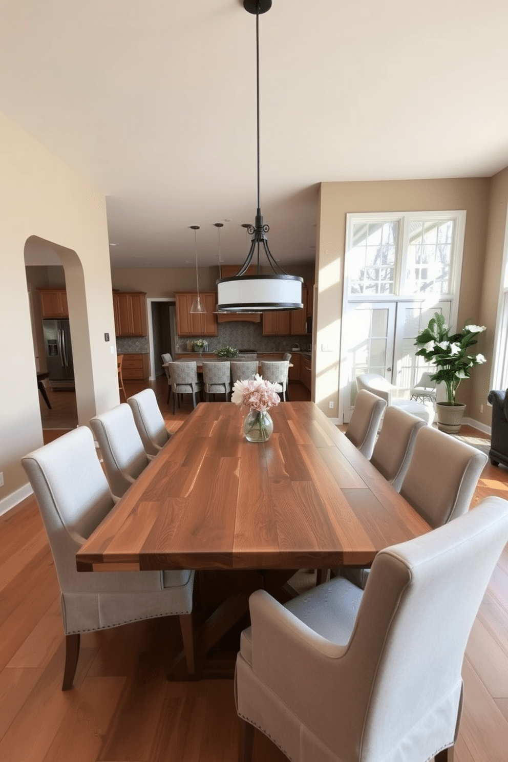 A family-friendly dining room features a large wooden table made from reclaimed oak, surrounded by comfortable upholstered chairs in a durable fabric. The walls are painted in a warm beige tone, and large windows allow natural light to flood the space, creating an inviting atmosphere. In the open floor plan, the dining area seamlessly connects to the kitchen and living room, fostering a sense of togetherness. A stylish pendant light hangs above the table, adding a modern touch to the cozy, functional design.