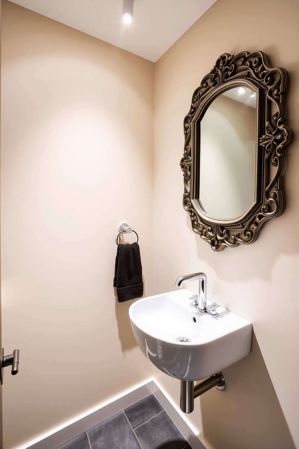 A stylish powder room featuring track lighting that enhances the versatility of the space. The walls are adorned with a soft, neutral paint color, and the flooring is a sleek, dark tile that complements the modern aesthetic. The track lighting is strategically placed to highlight a chic wall-mounted sink with a polished chrome faucet. A decorative mirror with an elegant frame reflects the warm glow of the lights, creating an inviting atmosphere.