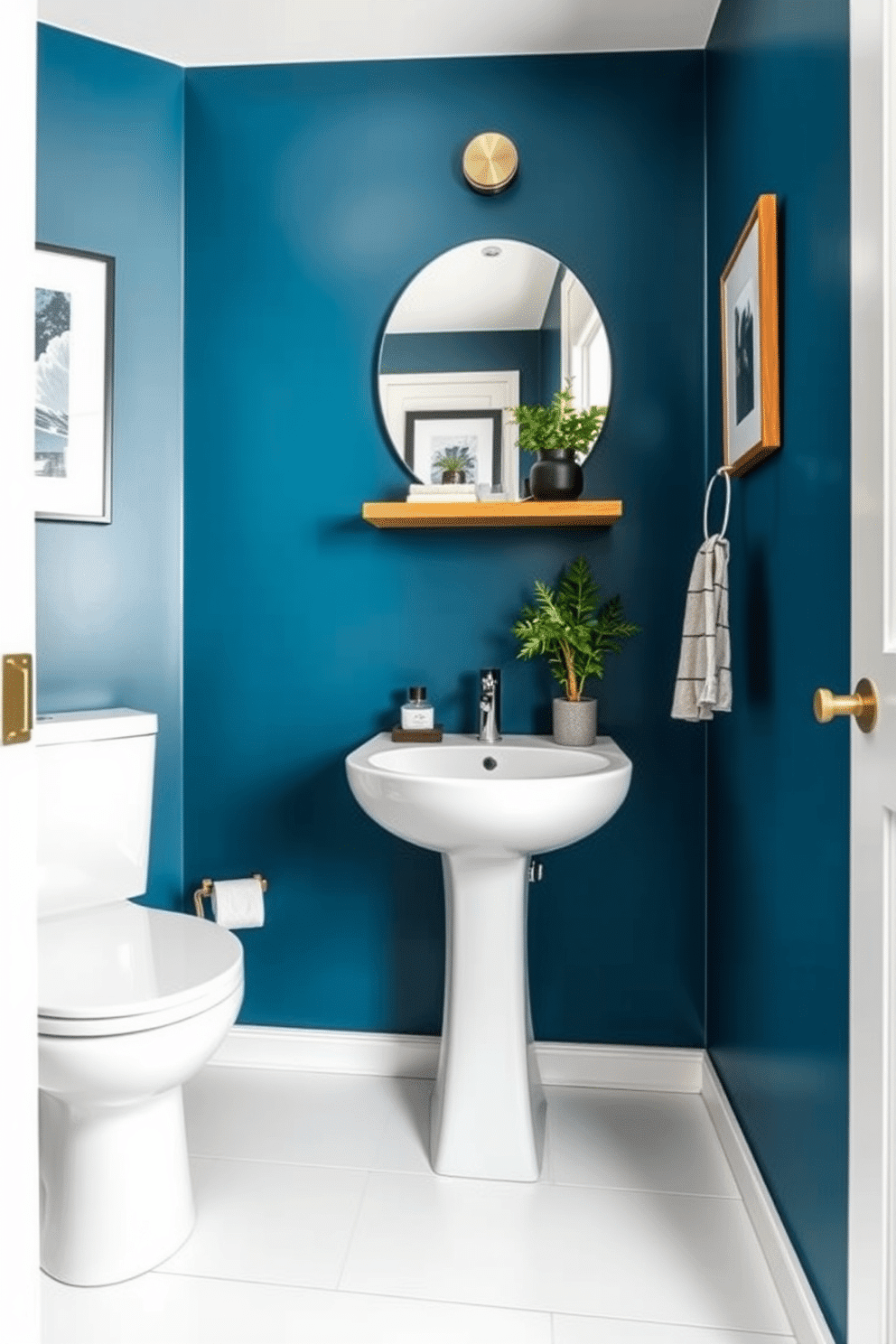 A chic powder room features walls painted in a striking steel blue, creating a contemporary edge that exudes sophistication. The space is complemented by sleek white fixtures, including a modern pedestal sink and a minimalist toilet, enhancing the clean lines of the design. To add warmth, a wooden accent shelf is mounted above the sink, showcasing decorative items and fresh greenery. The floor is adorned with large format white tiles, providing a bright contrast while maintaining a stylish and airy feel.