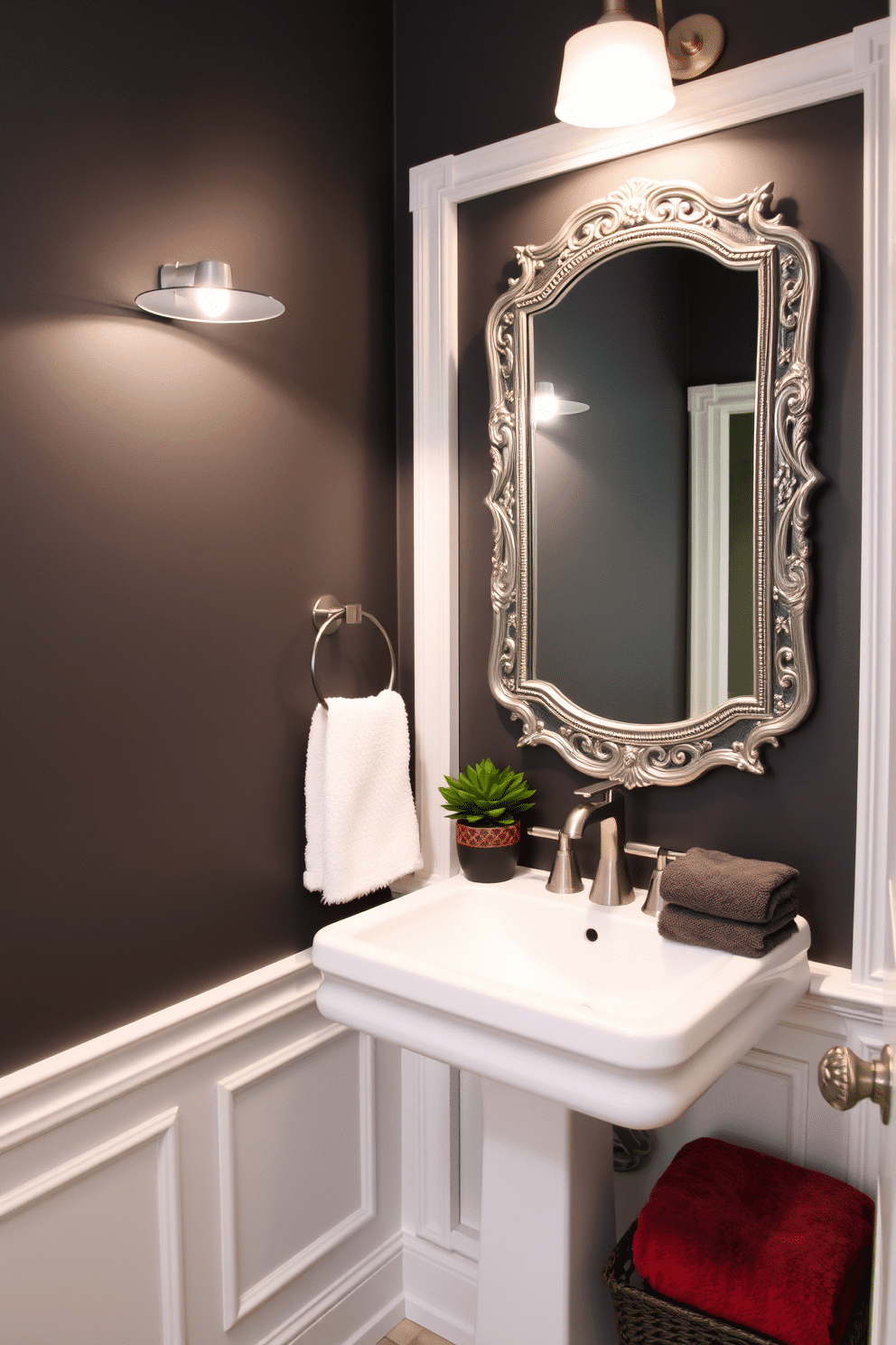 A chic powder room featuring charcoal gray walls accented with crisp white trim. The space is illuminated by a stylish pendant light, creating a warm and inviting atmosphere. A sleek white pedestal sink is positioned against the wall, complemented by a decorative mirror with an ornate frame. To enhance the design, a small potted plant adds a touch of greenery on the countertop, while plush towels in contrasting colors are neatly arranged.