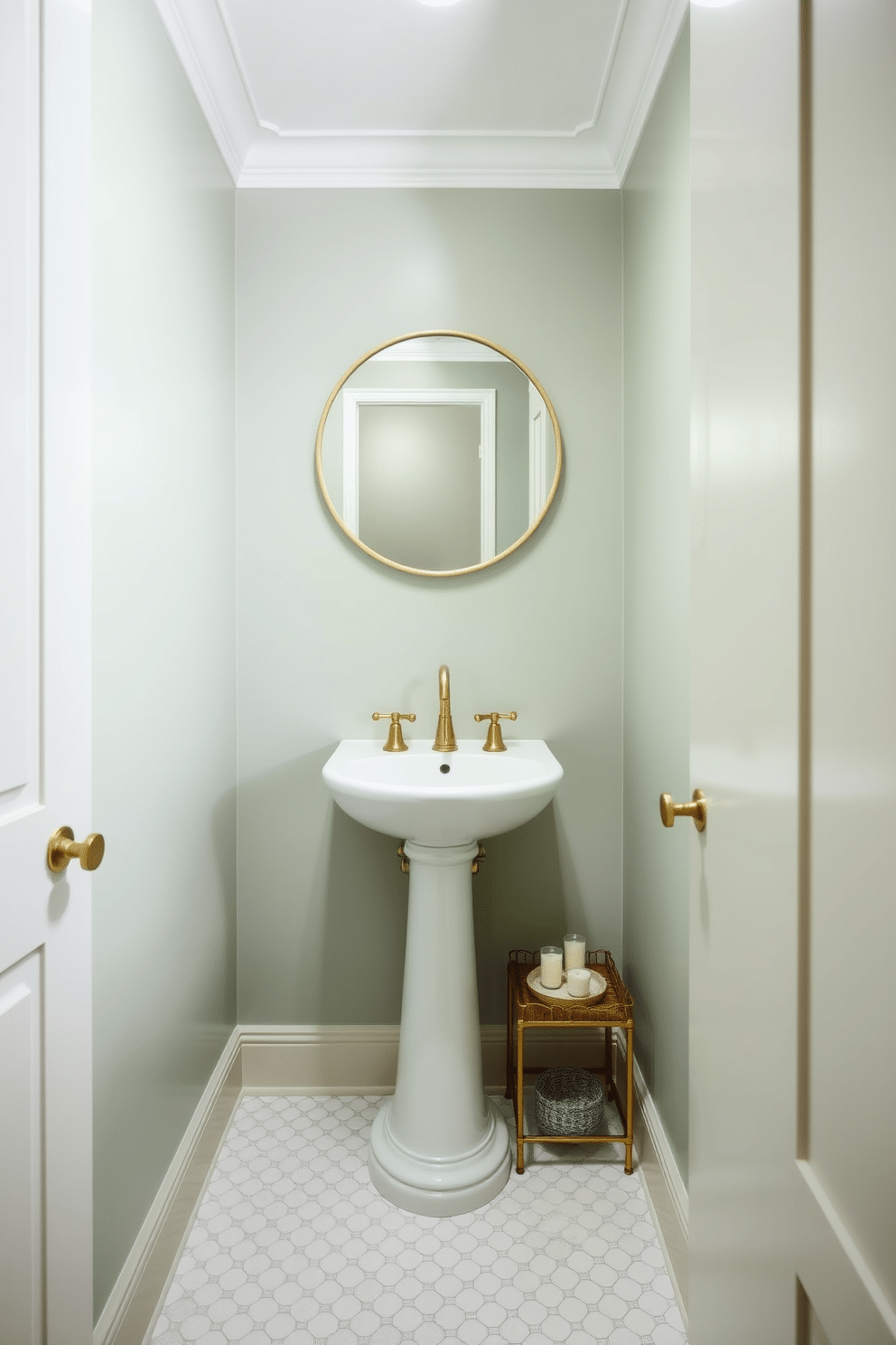 A stylish powder room with muted sage green walls that create a fresh and calming atmosphere. The space features a sleek pedestal sink with elegant gold fixtures, complemented by a round mirror with a minimalist frame above it. The floor is adorned with classic white hexagonal tiles, adding a touch of timeless charm. A small wooden shelf holds decorative items, including a potted plant and scented candles, enhancing the room's inviting ambiance.