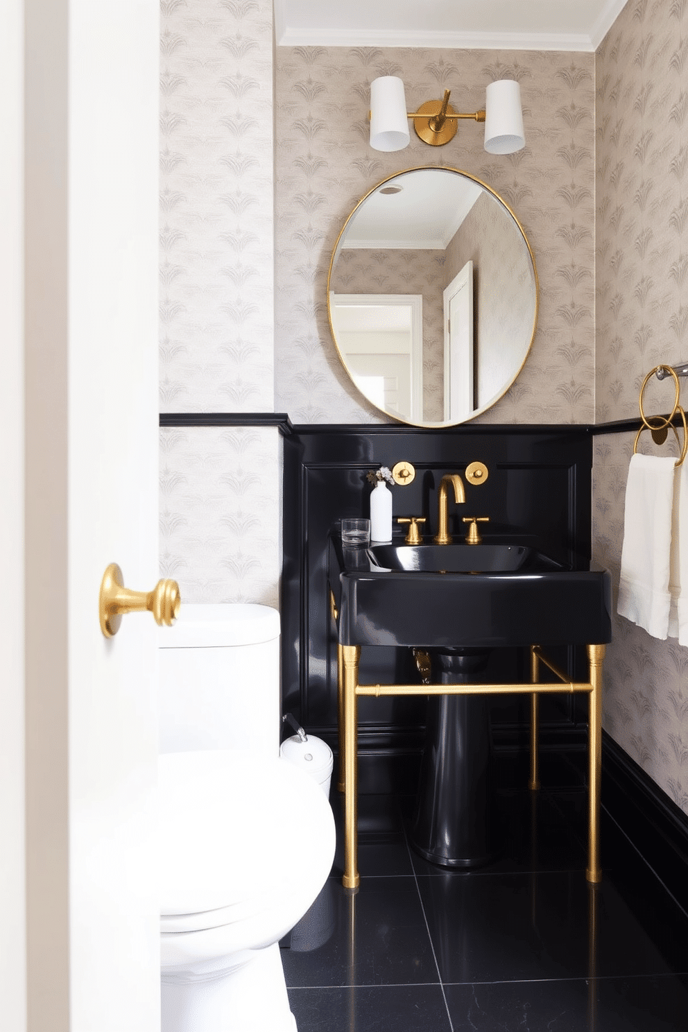 A chic powder room featuring a bold black sink with elegant gold fixtures. The walls are adorned with a soft, neutral wallpaper, and the floor is laid with glossy black tiles for a modern touch.