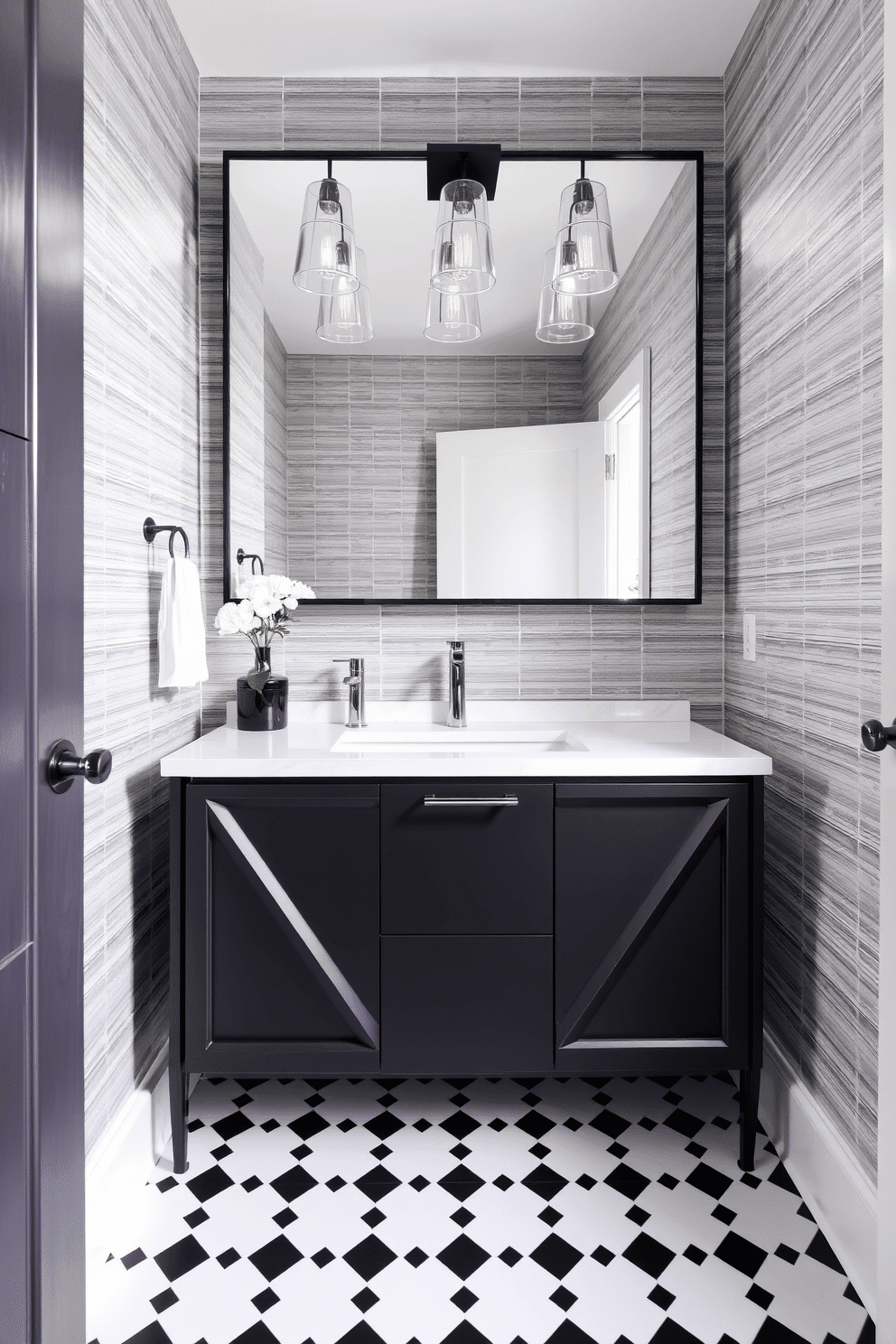 A modern powder room featuring a sleek black vanity with geometric shapes and clean lines. The vanity is complemented by a striking white quartz countertop that contrasts beautifully with the dark cabinetry. Above the vanity, a large, frameless mirror enhances the sense of space, reflecting the elegant lighting fixtures that hang above. The walls are adorned with a textured wallpaper in soft gray tones, while the floor is finished with chic black and white tiles for a sophisticated touch.