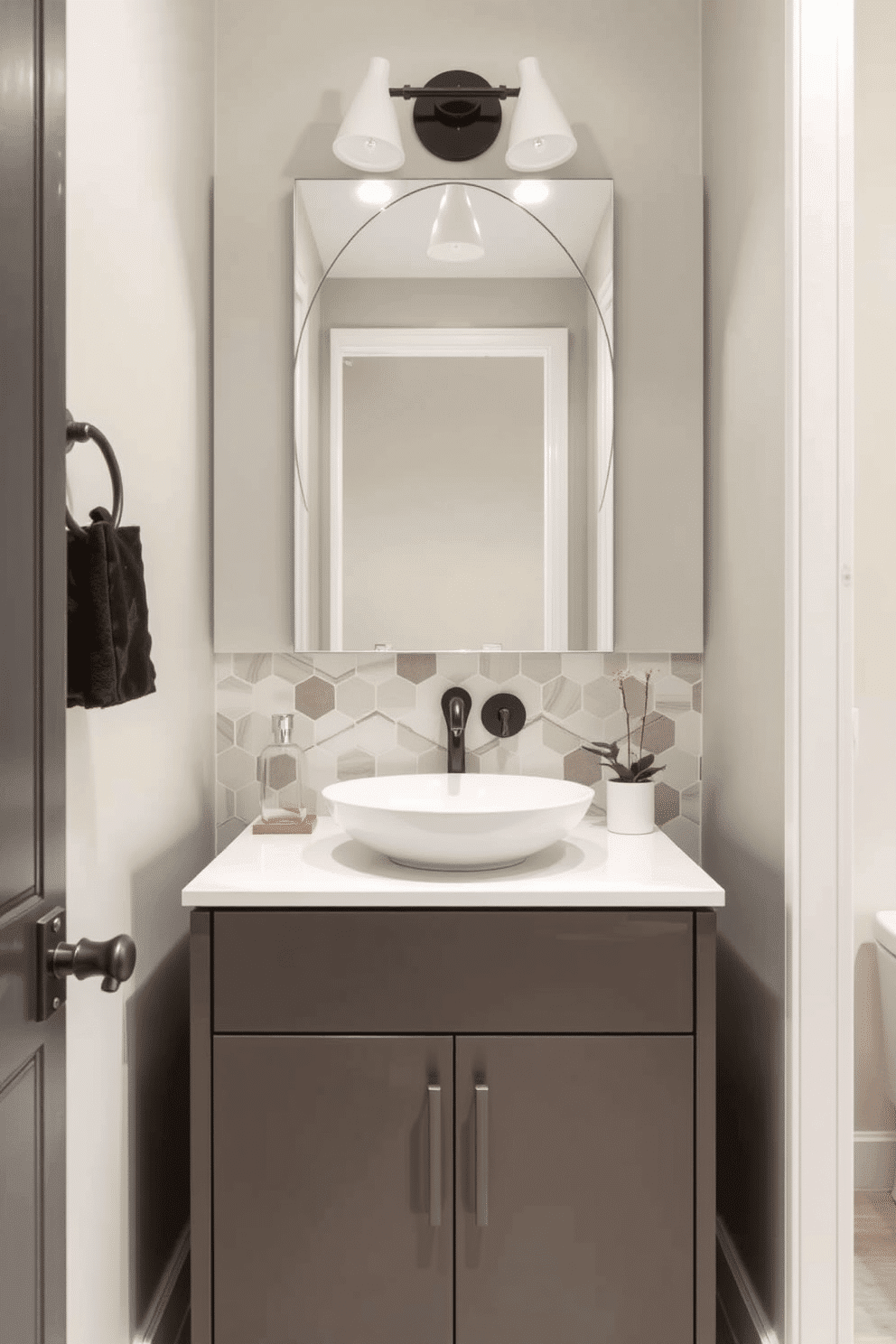 A contemporary powder room featuring a sleek vanity with unique hardware that adds a touch of artistic flair. The vanity is complemented by a stylish vessel sink and a striking backsplash made of geometric tiles in soft neutral tones.