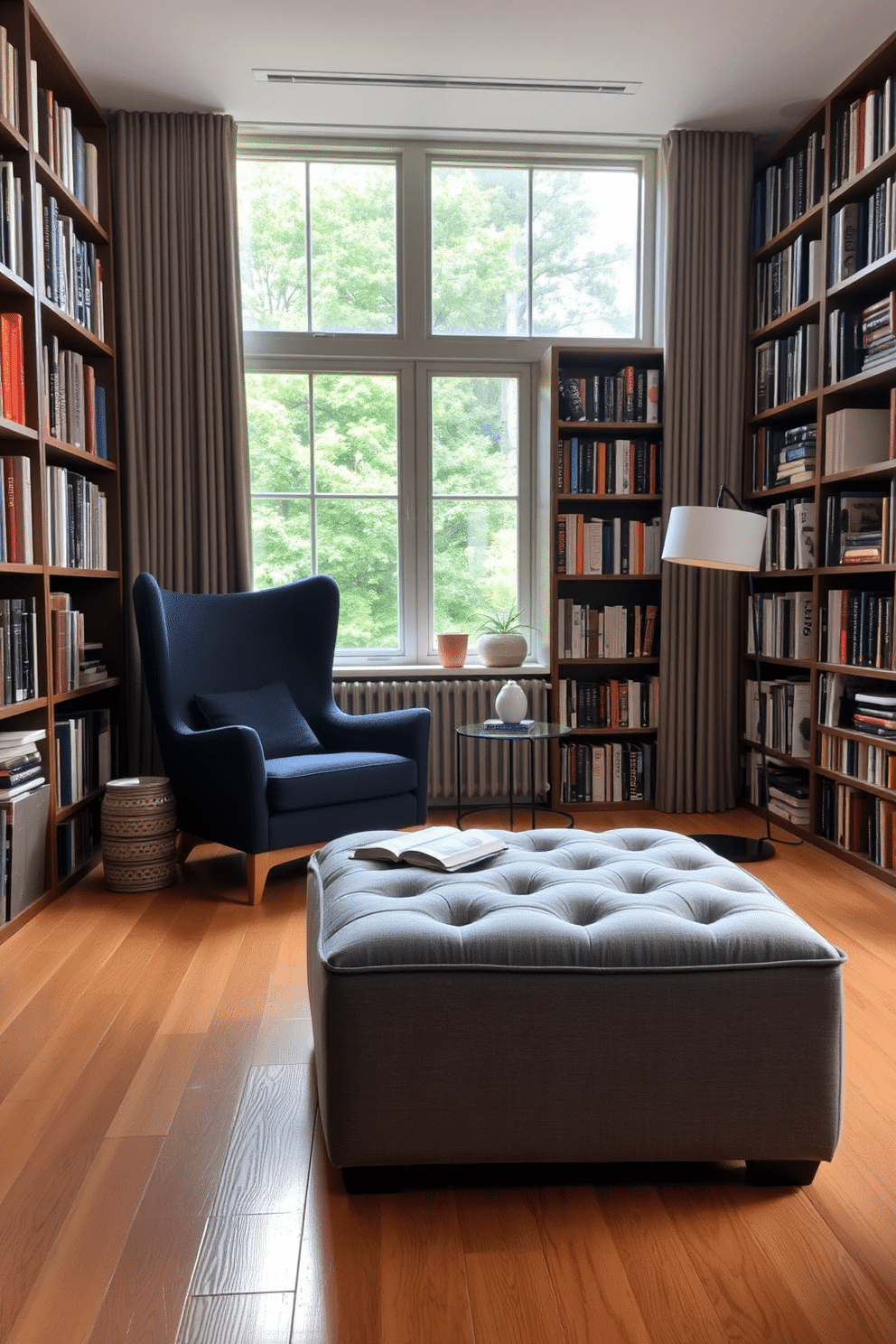 A stylish ottoman upholstered in soft gray fabric sits in the center of a cozy reading room, providing additional seating and a touch of elegance. Surrounding the ottoman are tall bookshelves filled with an array of books, while a large window allows natural light to flood the space, highlighting the warm wooden floor. The home library features a comfortable armchair in a deep navy hue, paired with a sleek side table for drinks and snacks. Soft lighting from a modern floor lamp creates an inviting atmosphere, perfect for curling up with a good book on a rainy afternoon.