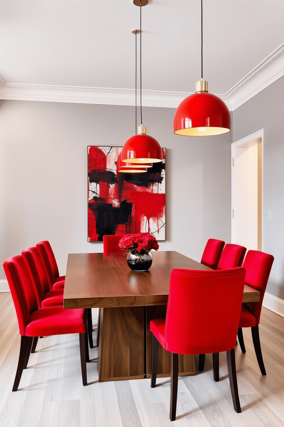 A modern dining room featuring a sleek wooden table surrounded by elegant red upholstered chairs. Above the table, striking red pendant lights hang from the ceiling, casting a warm glow over the space. The walls are painted in a soft gray, complementing the bold red accents. A large abstract painting in red and black serves as a focal point, enhancing the contemporary feel of the room.