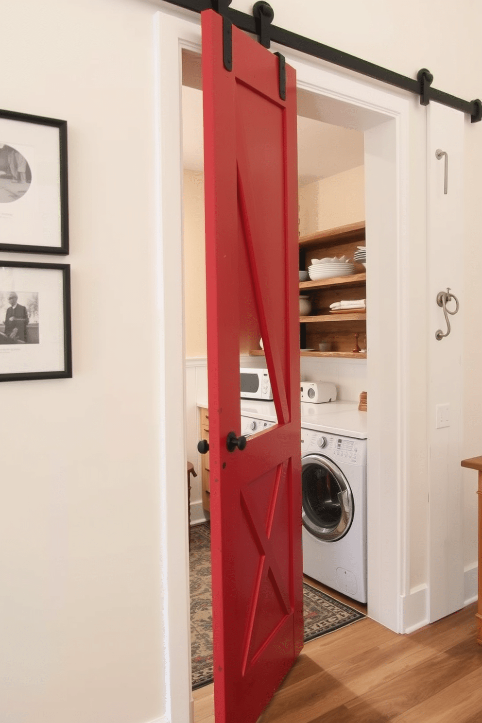 A rustic red barn door swings open to reveal a charming laundry room, featuring vintage-inspired appliances and open shelving made of reclaimed wood. The walls are painted in a soft cream color, while a patterned rug adds warmth to the space, complementing the vibrant red of the door.