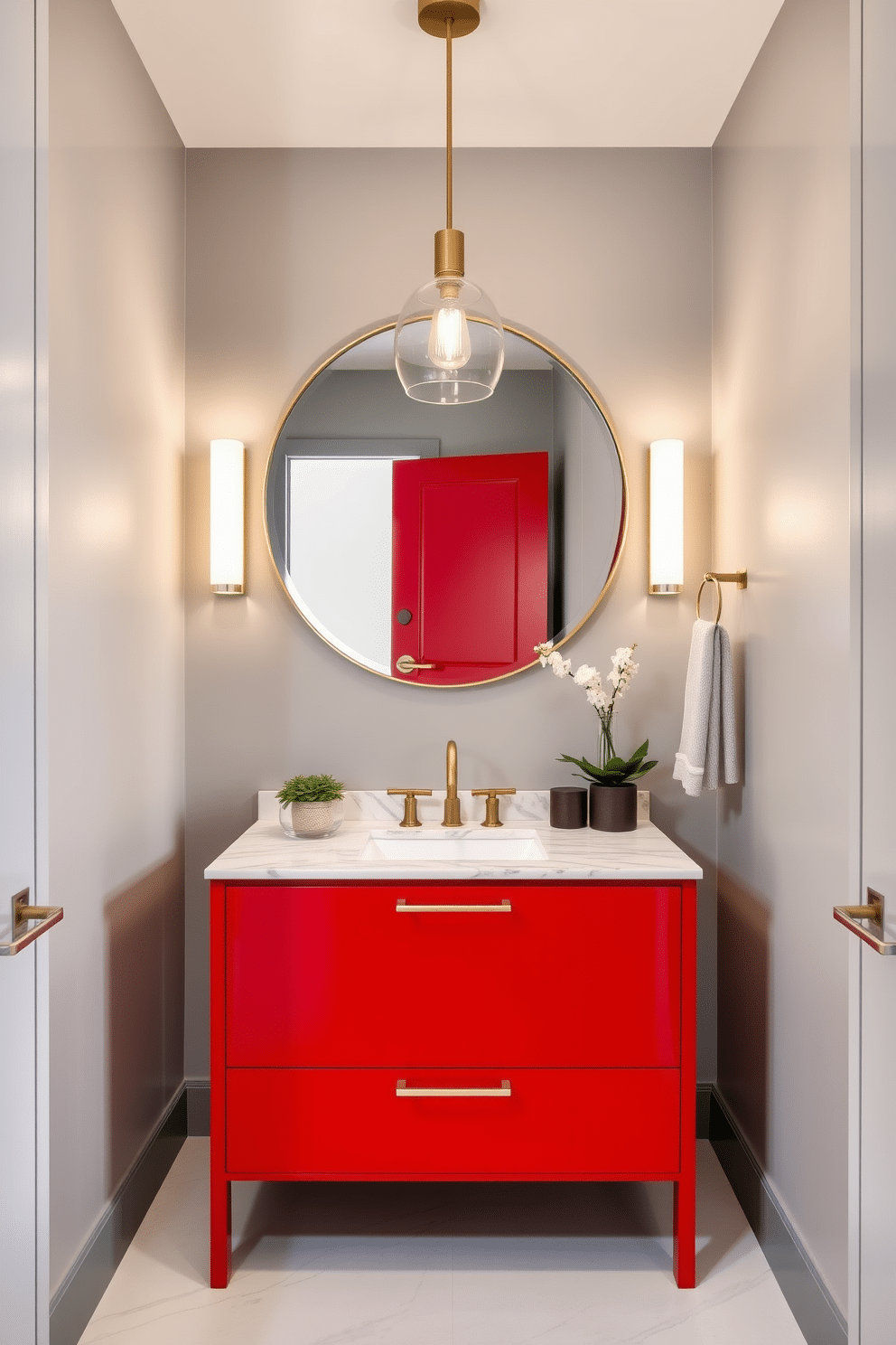 A sleek red vanity with a polished marble countertop serves as the centerpiece of this stylish powder room. The walls are adorned with a soft gray hue, complementing the bold vanity and enhancing the room's modern elegance. Above the vanity, a large round mirror framed in brushed gold reflects the contemporary fixtures. A chic pendant light hangs from the ceiling, casting a warm glow over the space, while a small potted plant adds a touch of greenery to the countertop.