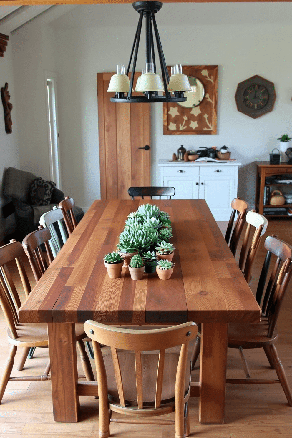 A rustic dining room features a large wooden table made from reclaimed barn wood, surrounded by mismatched chairs that add character. On the table, succulent plants in terracotta pots serve as vibrant centerpieces, bringing a touch of greenery to the warm, earthy tones of the space.