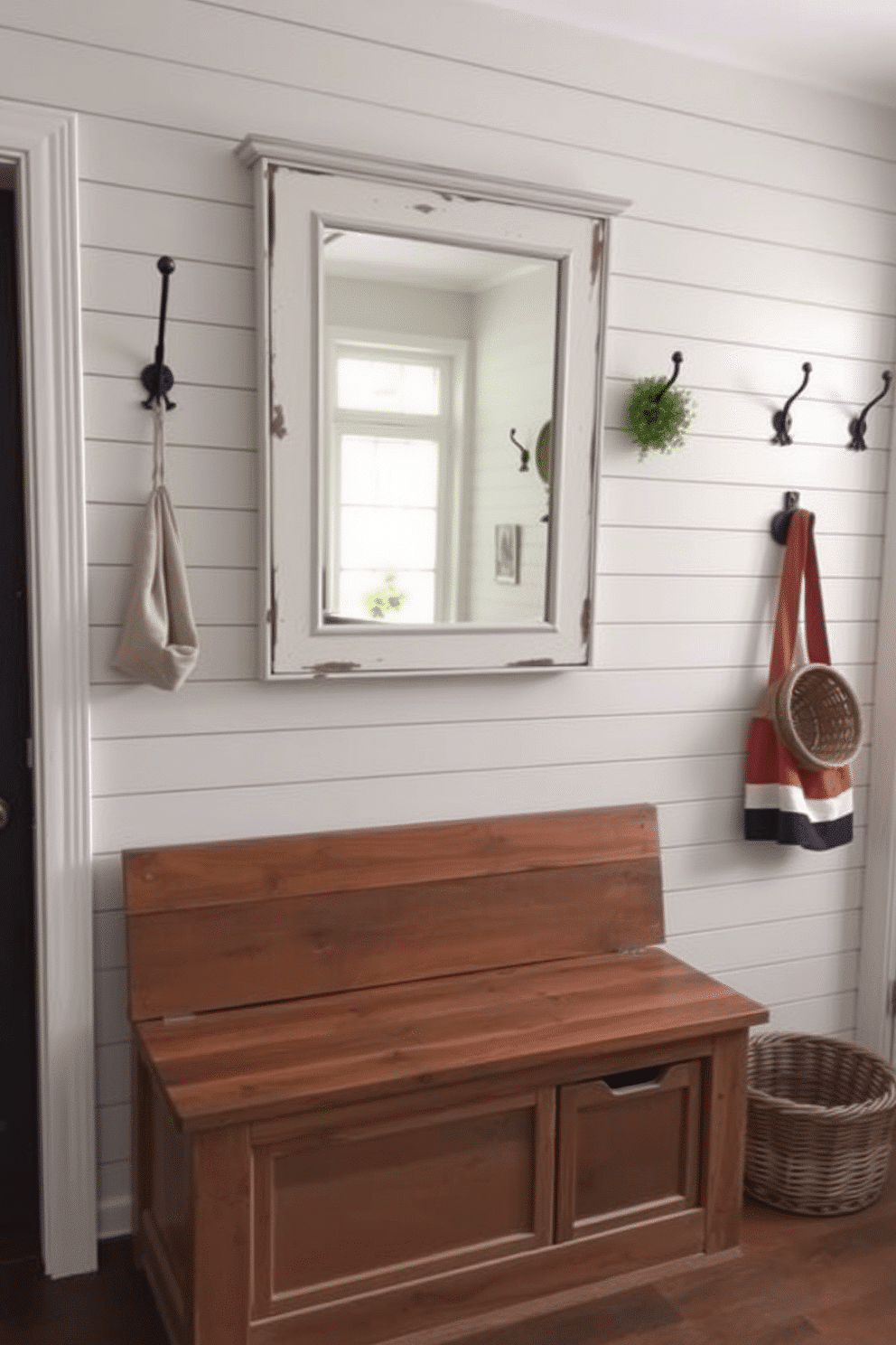 Layered rugs in a cozy living space create a sense of warmth and texture. The top rug features a vibrant pattern, while a larger, neutral base rug anchors the design beneath. A rustic mudroom combines functionality with charm, featuring reclaimed wood benches and hooks for storage. The walls are adorned with shiplap, and a durable, patterned tile floor adds both style and practicality.