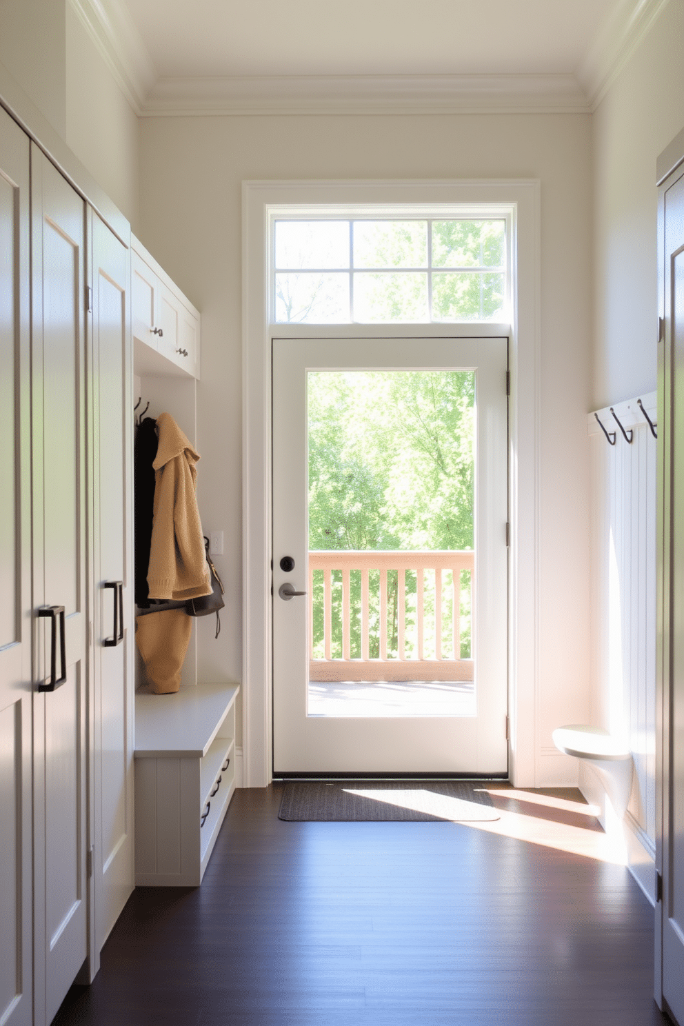 A welcoming mudroom features a glass door that invites abundant natural light, enhancing the airy atmosphere. The space is designed with simple yet functional elements, including a built-in bench with storage underneath and hooks for coats and bags.