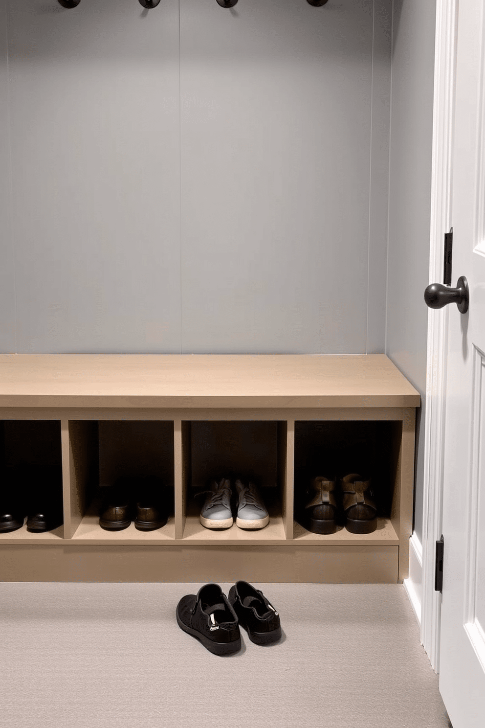 A functional mudroom featuring a sleek bench with hidden storage compartments beneath the seat, perfect for stashing shoes and outdoor gear. The walls are painted in a soft gray, complemented by a durable, textured floor that can withstand heavy foot traffic.