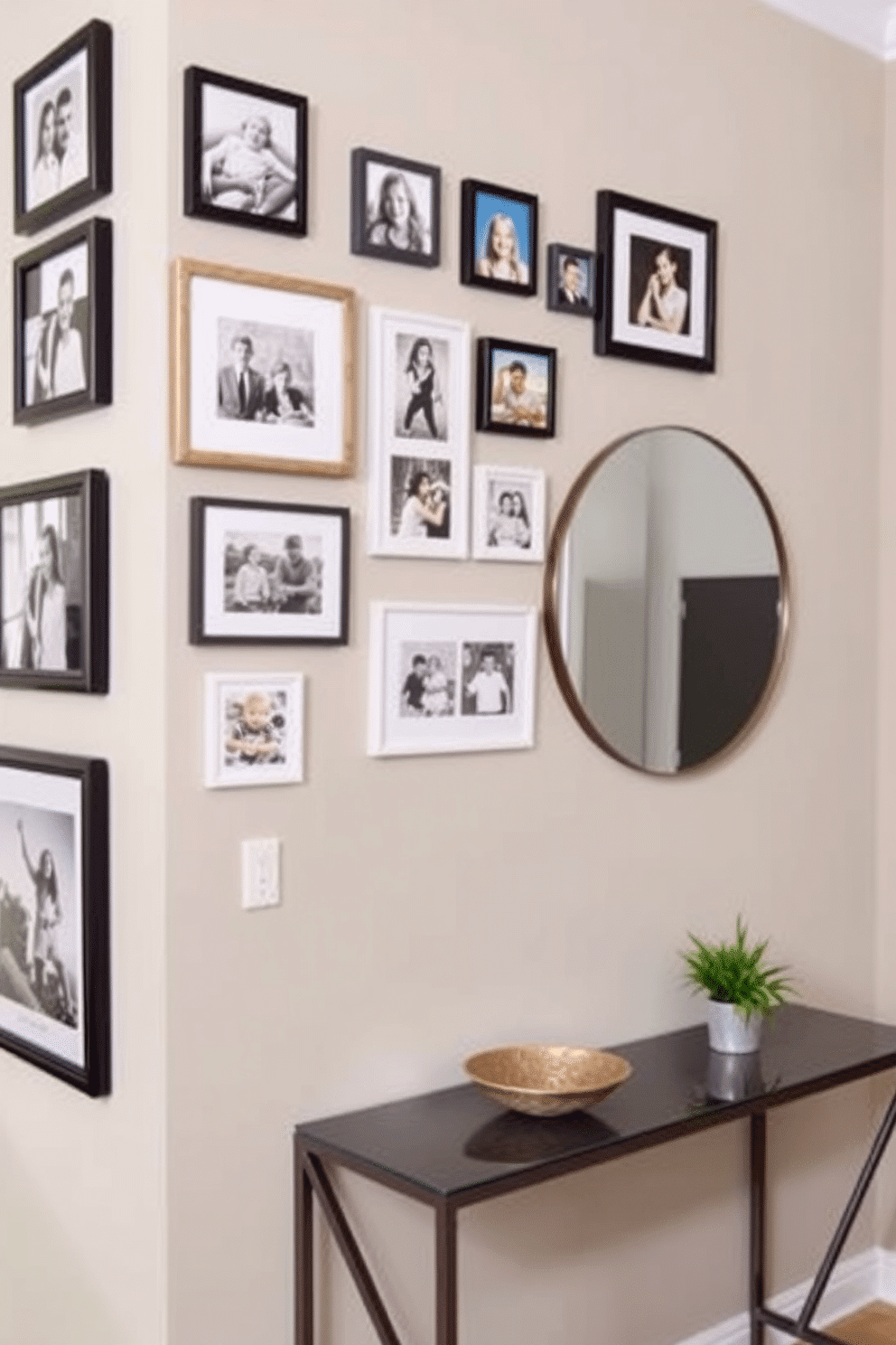 A gallery wall adorned with family photos, showcasing a mix of framed black-and-white and colorful images. The wall is painted in a soft gray, providing a neutral backdrop that enhances the vibrant frames and personal memories. A small entryway featuring a sleek console table with a decorative bowl and a small plant. The walls are painted in a warm beige, and a round mirror hangs above the table, reflecting light and creating a welcoming atmosphere.