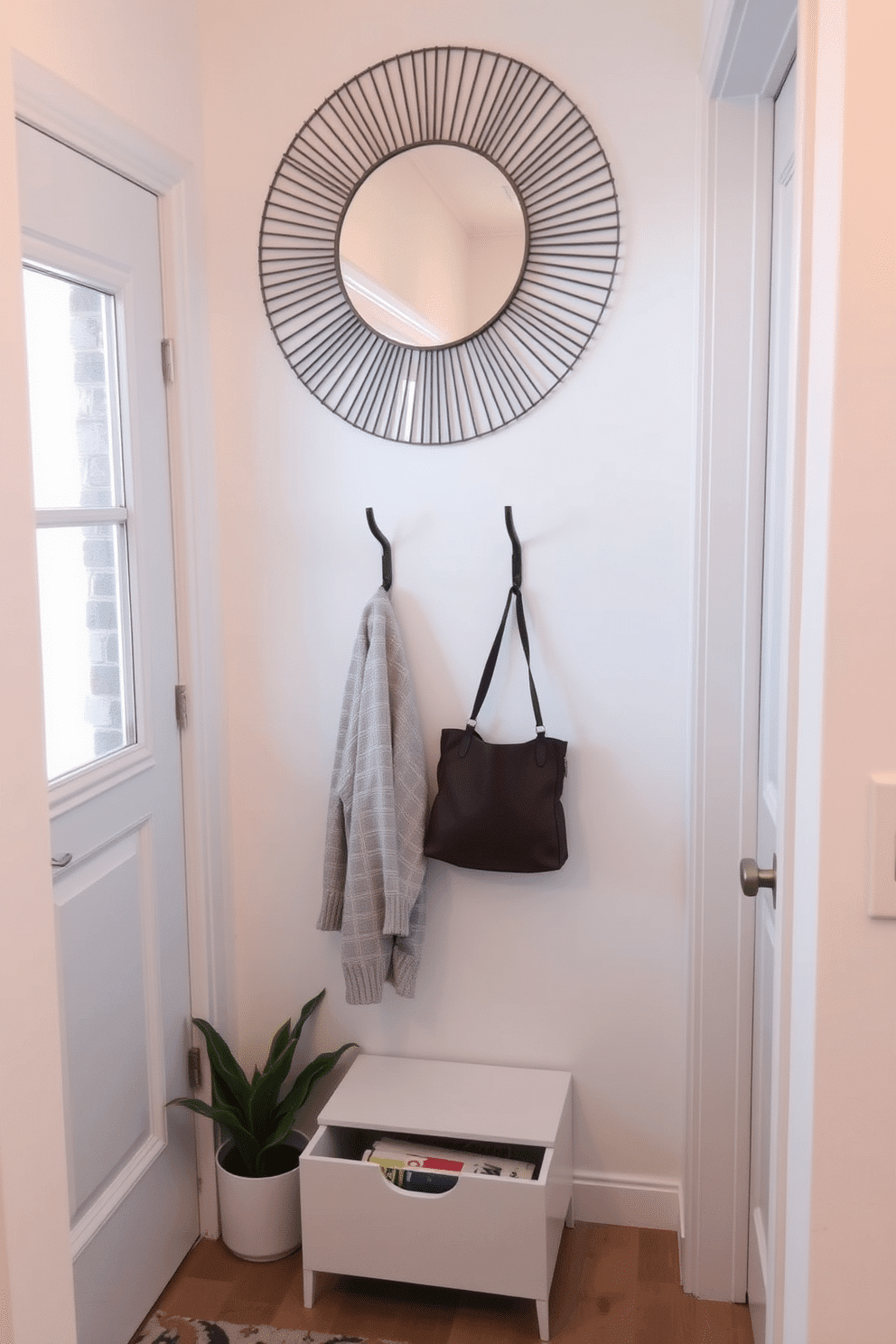 A small entryway features a sleek coat rack with a storage drawer beneath it, perfect for keeping essentials organized. The walls are painted in a soft, welcoming hue, and a small potted plant adds a touch of greenery beside the door. The coat rack is designed with minimalist lines, combining functionality with style. A decorative mirror hangs above it, reflecting light and creating an illusion of space in the compact area.