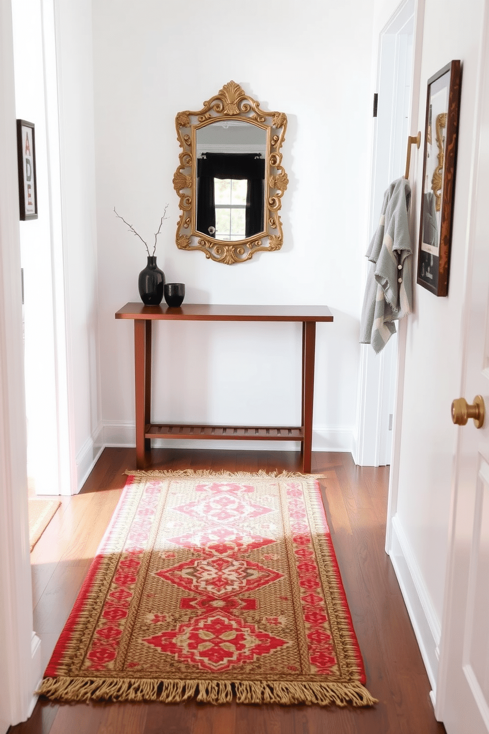 A cozy small entryway features layered rugs in varying textures, creating a warm and inviting atmosphere. The base rug is a soft, neutral jute, topped with a vibrant, patterned runner that adds a pop of color and visual interest. The walls are painted in a light, airy hue, complemented by a sleek console table in a rich wood finish. Above the table, a stylish mirror with an ornate frame reflects natural light, enhancing the space's openness and charm.