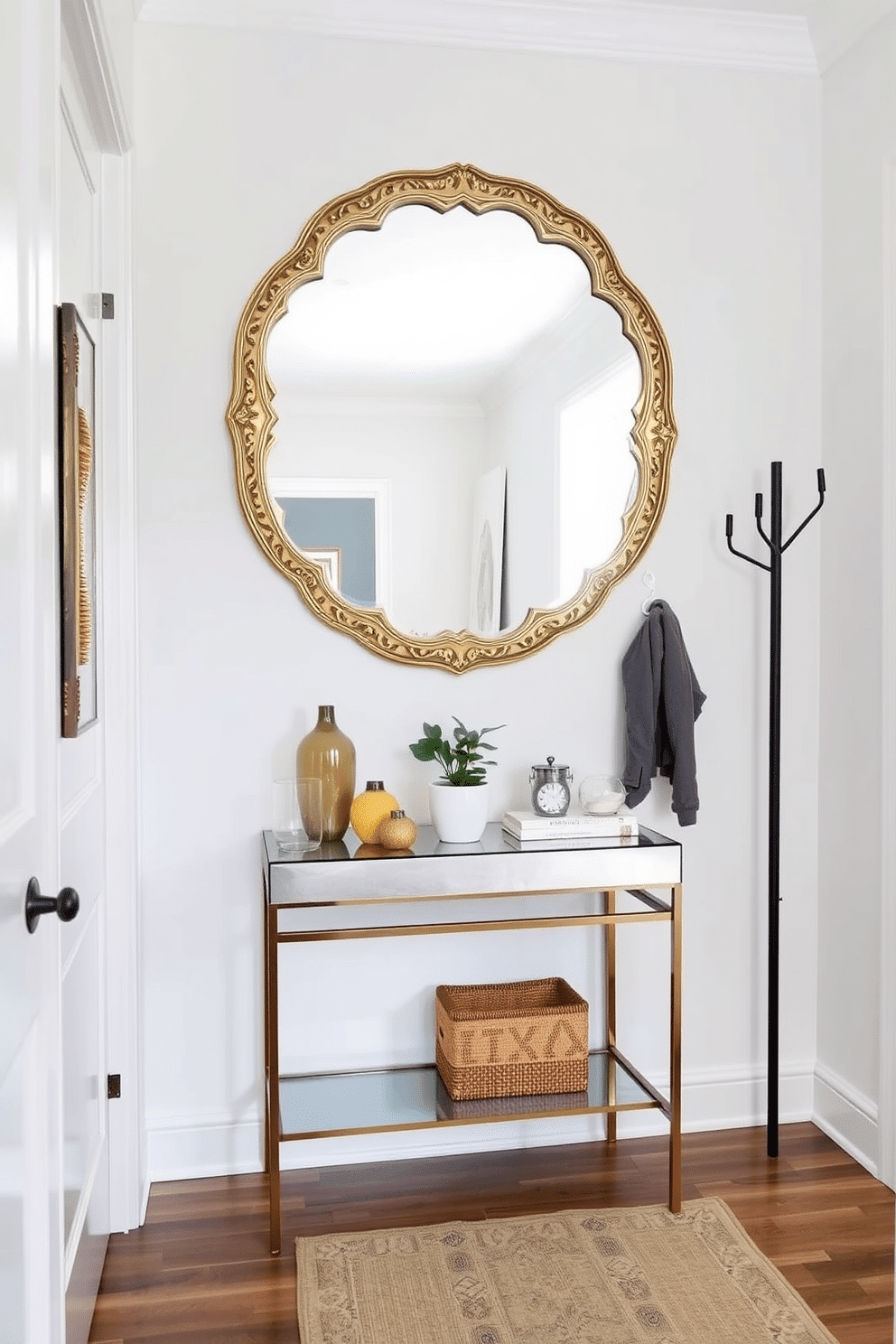 A small entryway features an artistic wall mirror that serves as the focal point, reflecting light and creating a sense of depth. The mirror is framed in an intricate gold design, complementing a sleek console table below adorned with decorative items and a small potted plant. The walls are painted in a soft, neutral tone to enhance the brightness of the space, while a stylish runner rug adds warmth and texture underfoot. To the side, a minimalist coat rack provides functionality without overwhelming the design, keeping the entryway organized and inviting.