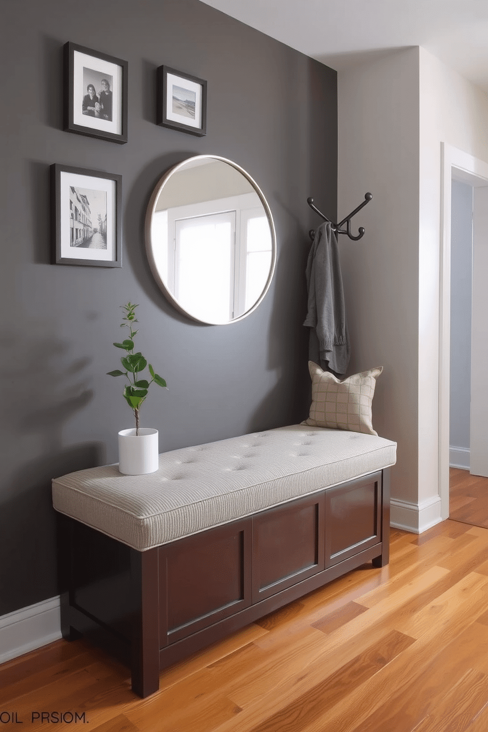 A cozy bench with storage underneath sits against the wall, upholstered in a soft, textured fabric. Above the bench, a series of framed art pieces add a personal touch, while a small potted plant brings a hint of greenery to the space. The foyer features warm wood flooring that complements the bench, creating an inviting atmosphere. A stylish wall-mounted coat rack provides functionality, and a round mirror above the bench enhances the sense of space and light.