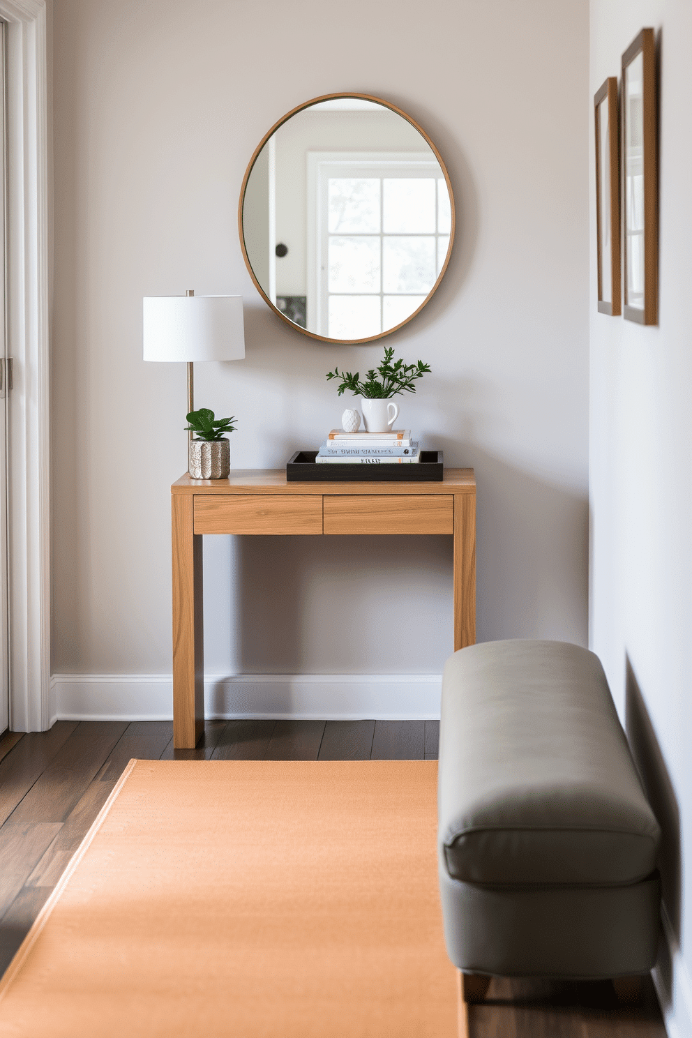 A small side table crafted from light oak wood stands against the wall, adorned with a stylish lamp and a small potted plant. The tabletop features a decorative tray that holds coasters and a stack of neatly arranged books, adding a touch of personality to the space. The foyer is designed with a minimalist approach, featuring a sleek console table with a mirror above it, reflecting natural light. A warm-hued runner rug leads into the home, while a few carefully selected art pieces hang on the walls, creating an inviting atmosphere.