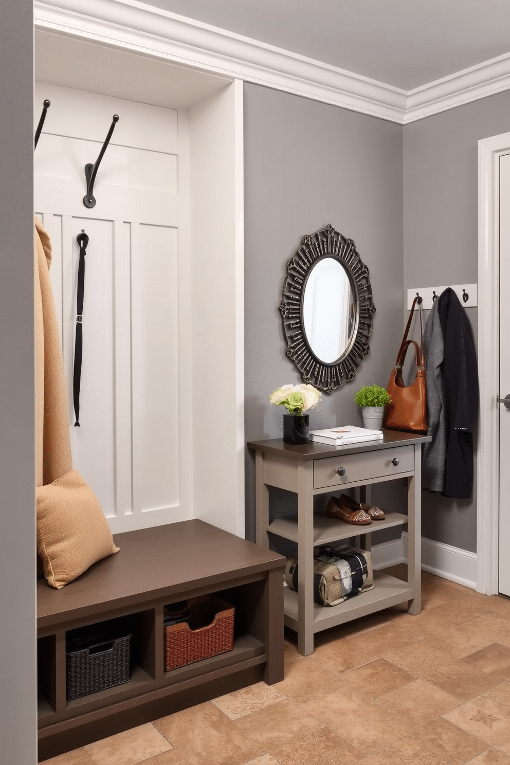 A stylish mudroom featuring multi-functional furniture that maximizes space efficiency. The design includes a built-in bench with storage compartments underneath and hooks above for hanging coats and bags. Adjacent to the bench, a slim console table serves as a landing spot for keys and mail, with a decorative mirror above to enhance the sense of space. The walls are painted in a soft gray, and the flooring is a durable, textured tile that withstands high traffic.