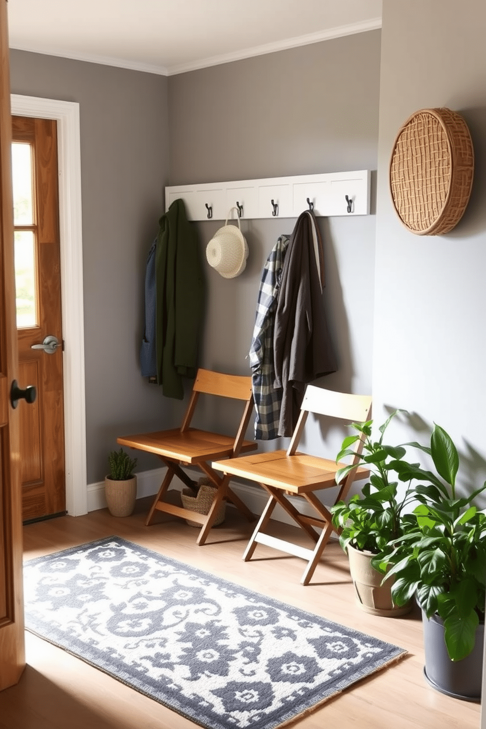 A cozy mudroom featuring small folding chairs for extra seating. The walls are painted a soft gray, complemented by a rustic wooden bench and hooks for coats, creating an inviting entryway. The small folding chairs are neatly tucked away against the wall, ready to be pulled out when needed. A patterned rug adds warmth to the space, while potted plants bring a touch of nature indoors.