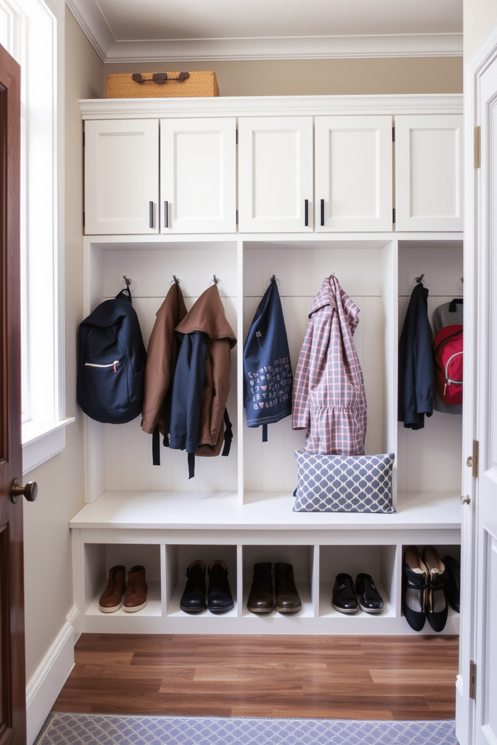 A welcoming mudroom features built-in cubbies designed for organized family gear, providing ample storage for shoes, coats, and backpacks. The space is illuminated by natural light from a nearby window, with a bench below the cubbies for easy seating while putting on or taking off shoes.